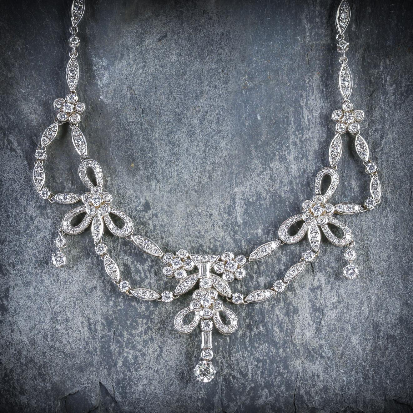 This stunning antique Platinum Diamond necklace is Edwardian, Circa 1910

The piece is adorned with sparkling old cut and baguette cut Diamonds set in a lovely setting decorated with flower motifs and Diamond droppers 

There are 17.50cts worth of