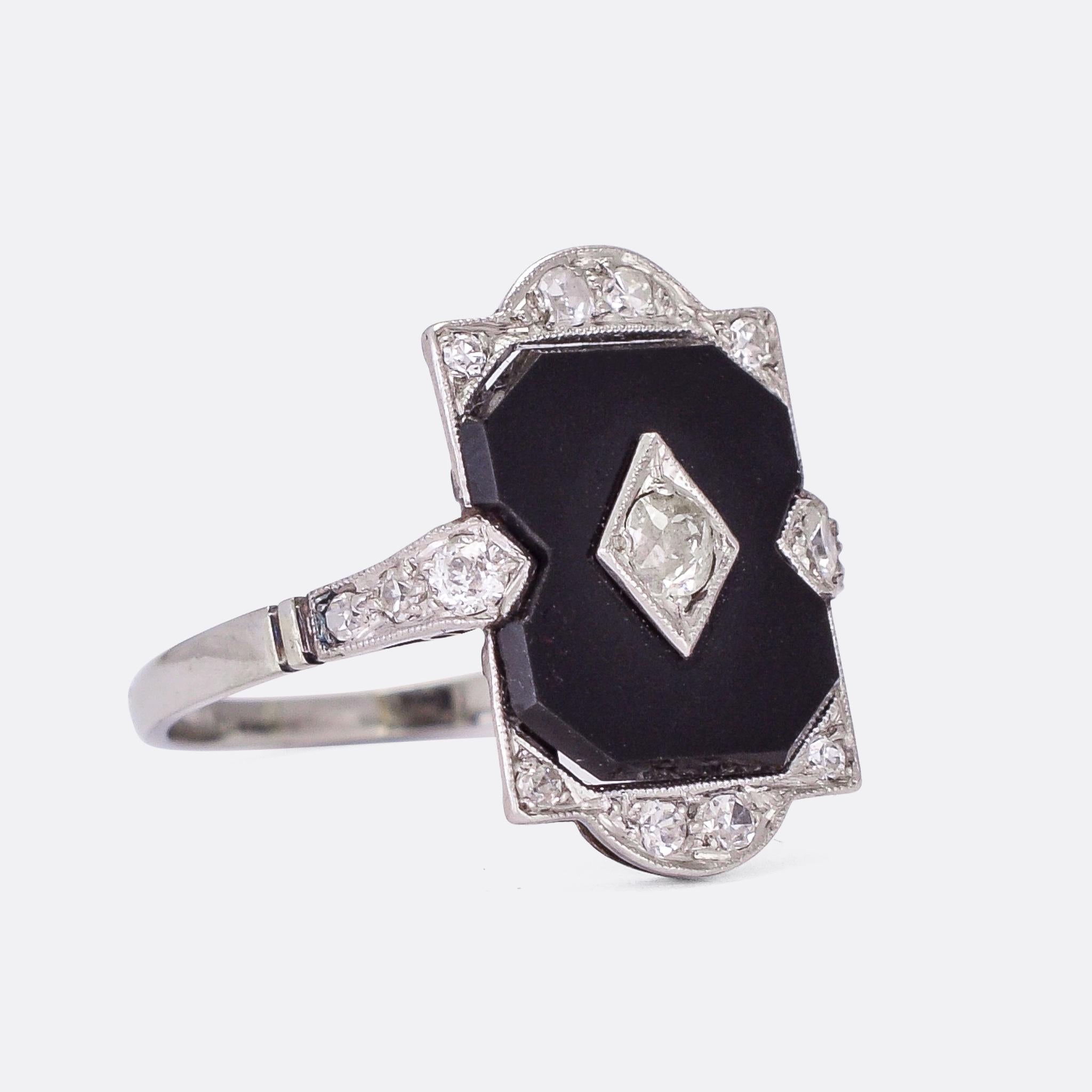 A stunning Edwardian era onyx & diamond panel ring crafted in platinum throughout. The deep black panel creates a bold contrast with the icy white diamonds and the millegrain platinum settings. It's handmade and dates from the early 20th Century,