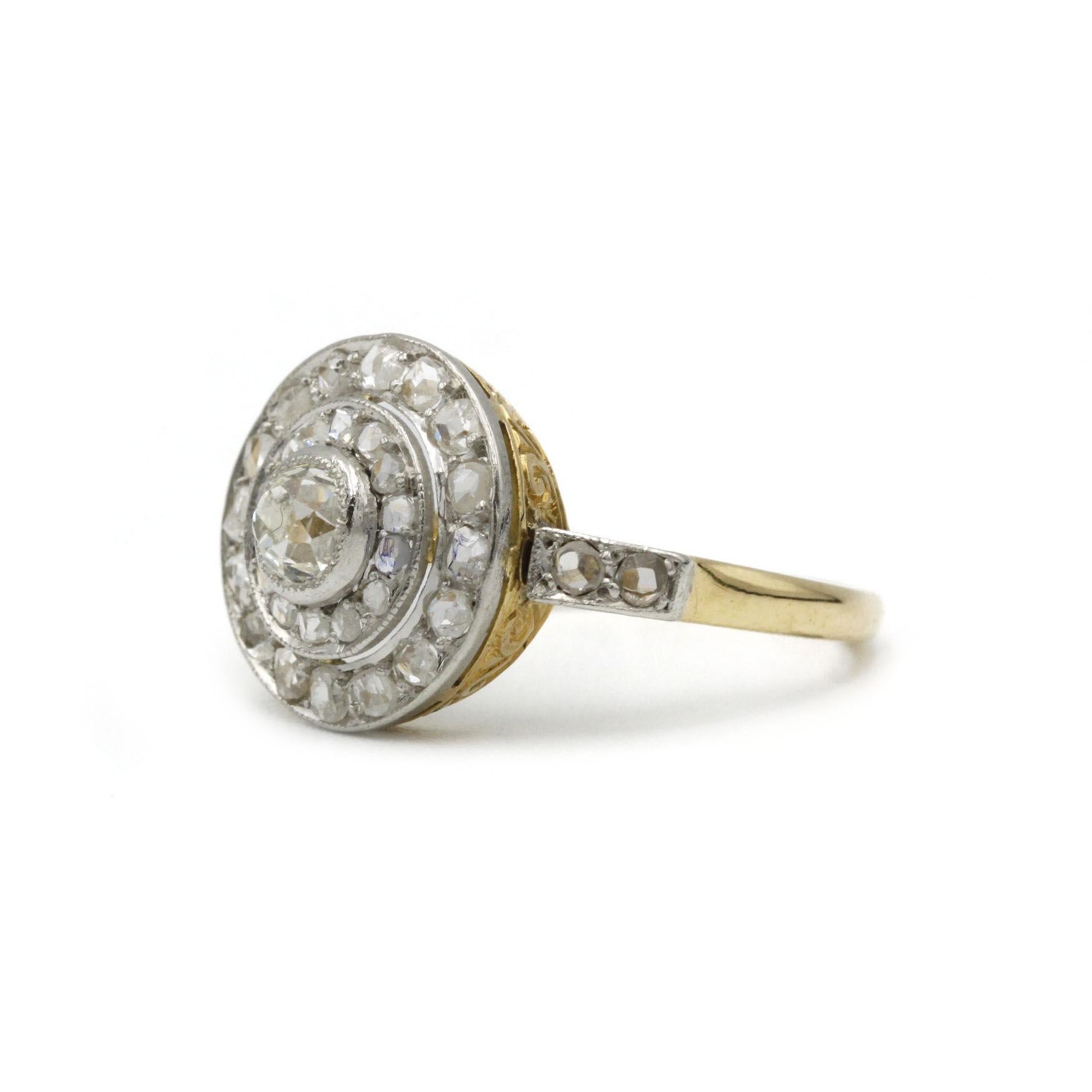 This exquisite antique ring exemplifies the refined elegance of the Edwardian era. Centered with a captivating old European cut diamond, the design radiates outward in concentric halos of shimmering rose-cut diamonds, gracefully arranged in a