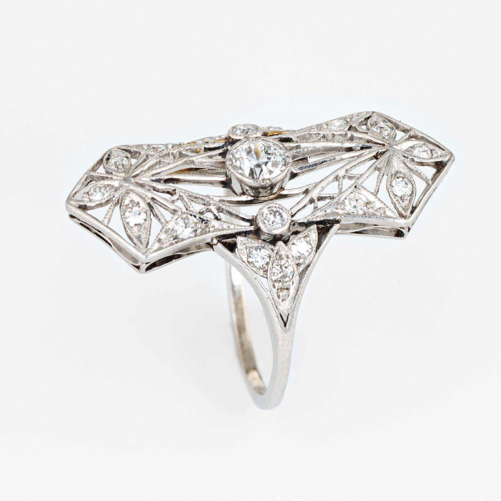 Bague édouardienne ancienne (circa 1900s à 1910s) finement détaillée, réalisée en platine 900. 

Le diamant taille ancienne mine, estimé à 0,25 carat, monté au centre, est accentué par 18 diamants estimés à 0,02 ou 0,03 carat. Le poids total des