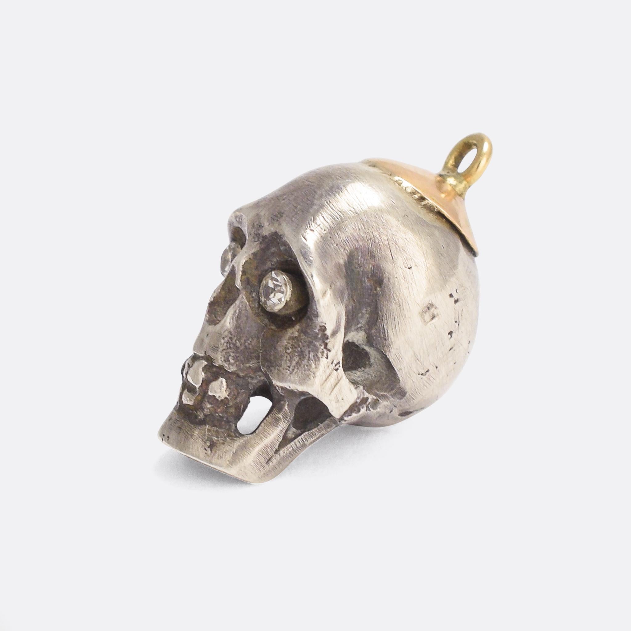 A cool antique skull pendant set with diamond eyes. It's crafted from solid Sterling Silver - a good size and weight with a gold top. It was made in the early 20th Century, circa 1910.

STONES 
Diamonds

MEASUREMENTS 
2.4 x 1.3 x 1.5cm (height by