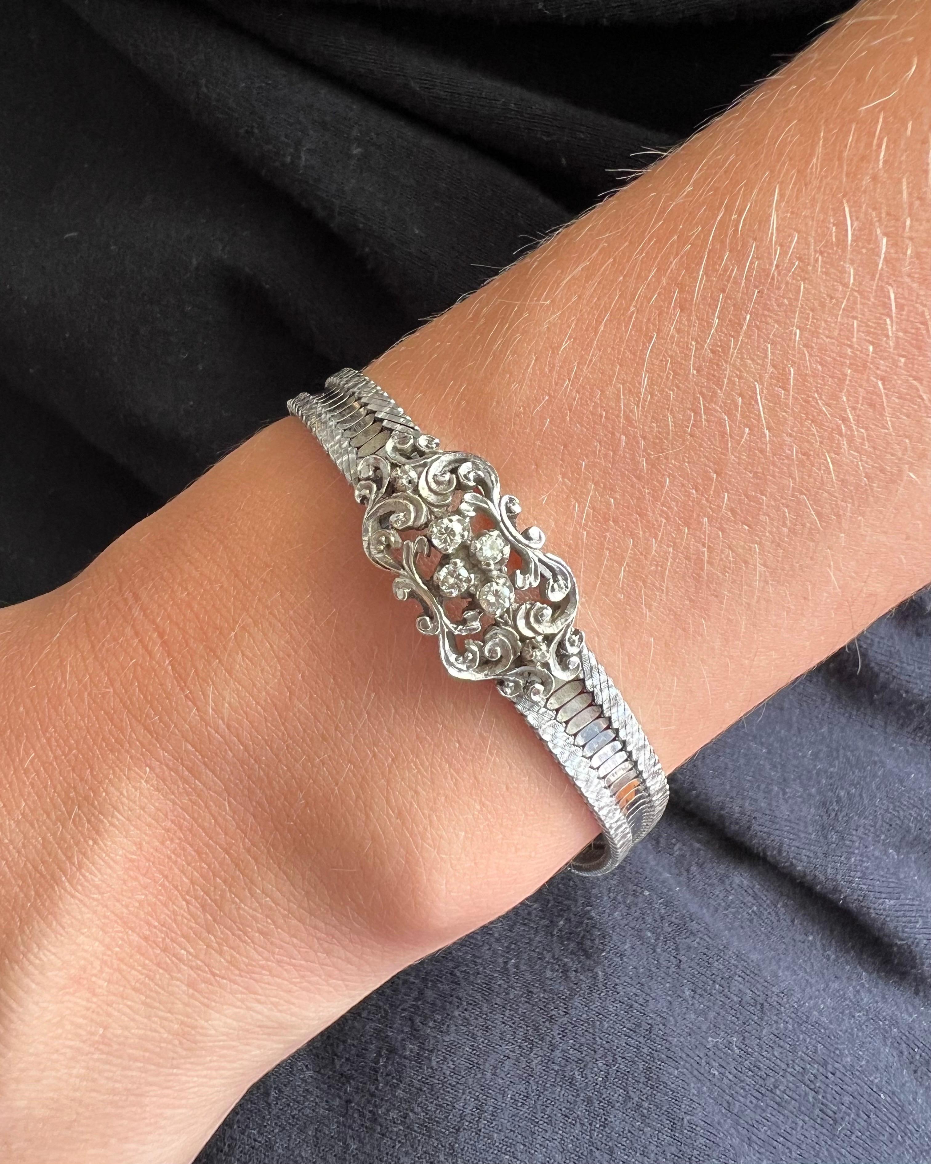 This is an antique Edwardian brilliant cut diamond snake chain bracelet. The beautiful bracelet consist of brilliant cut diamonds, set in a floral white gold frame. This white gold bracelet is created with a chased frame in the center set with four