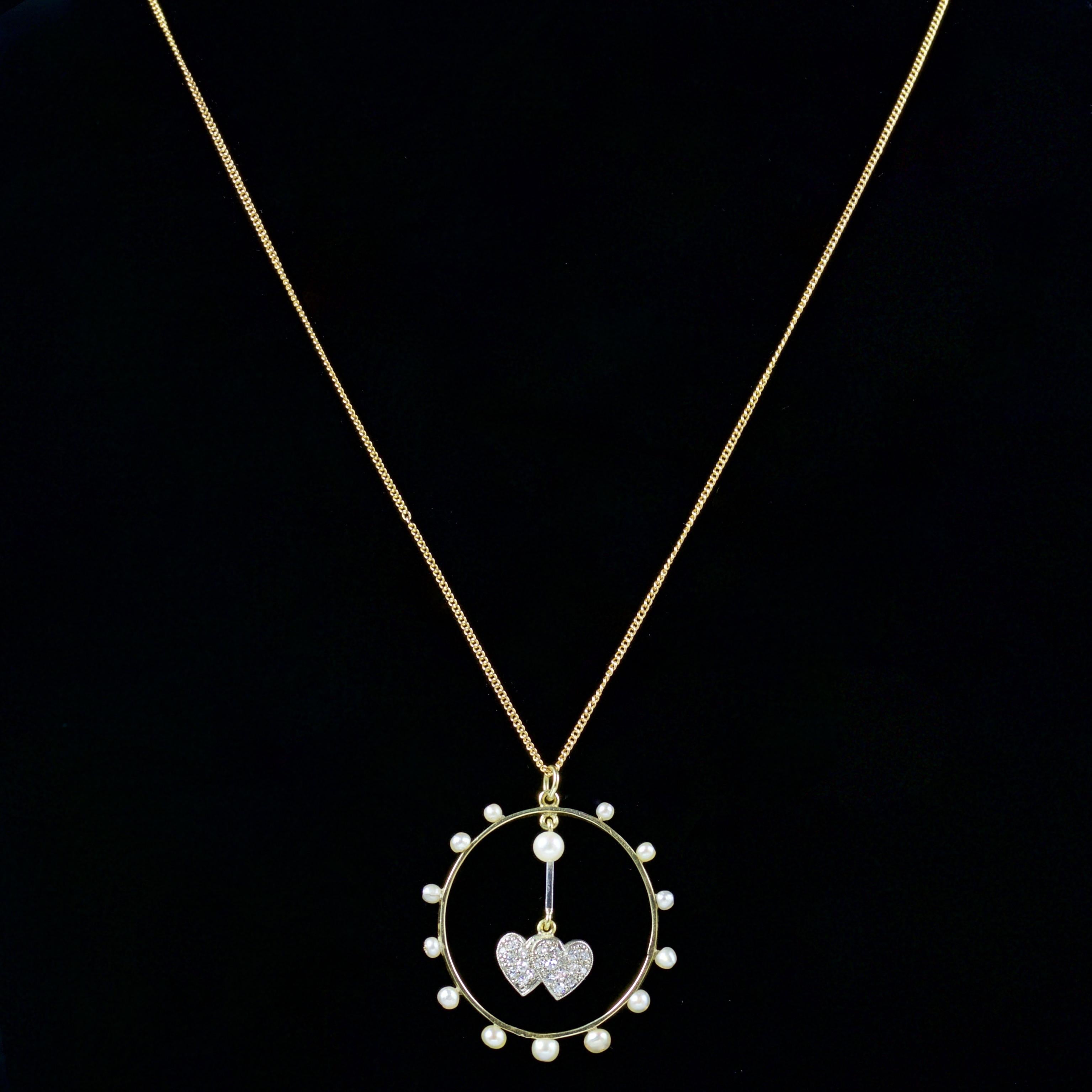 This fabulous Edwardian double heart Diamond pendant is set in 18ct Yellow Gold, Circa 1915.

The pendant is adorned with a halo of Pearls, with a double heart in the centre which hangs freely and set in a Diamonds.

There are 0.60ct of Diamonds,