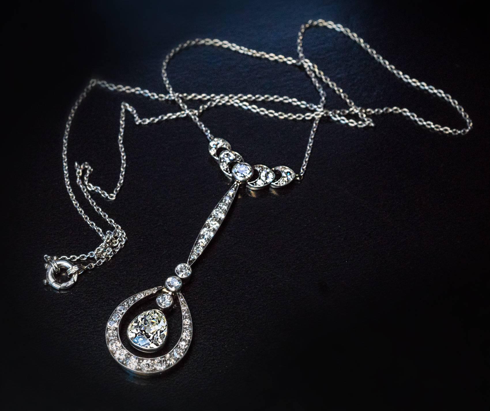 Circa 1910

This stylish antique Edwardian era drop shaped diamond necklace is finely crafted in silver topped 14K gold and platinum (chain). The principal stone of the necklace is a sparkling old pear cut diamond set in a bezel. The diamond