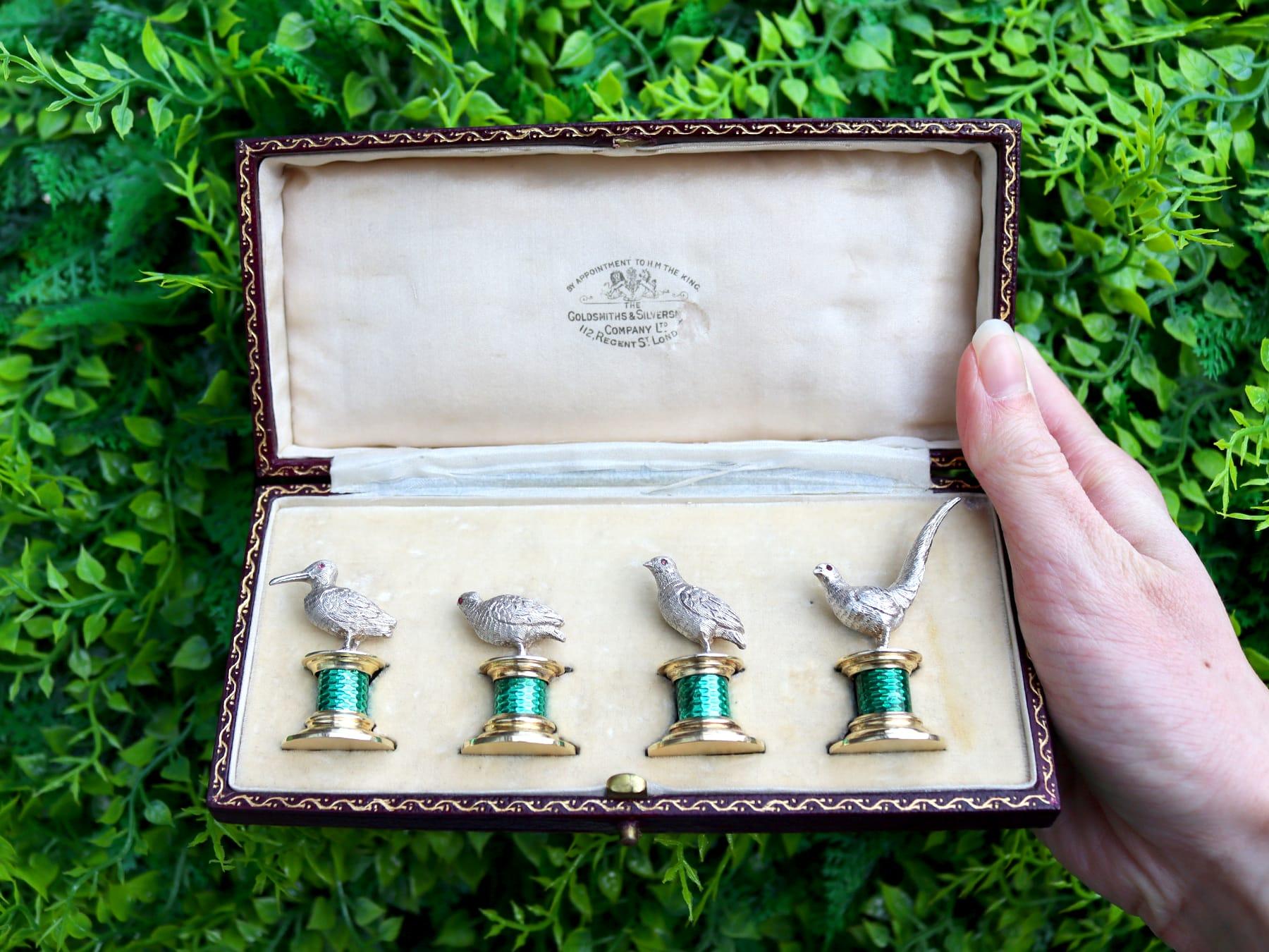 An exceptional, fine and impressive set of four antique Edwardian English sterling silver and enamel bird menu / card holders - boxed; an addition to our diverse dining silverware collection.

These exceptional antique Edwardian cast sterling silver