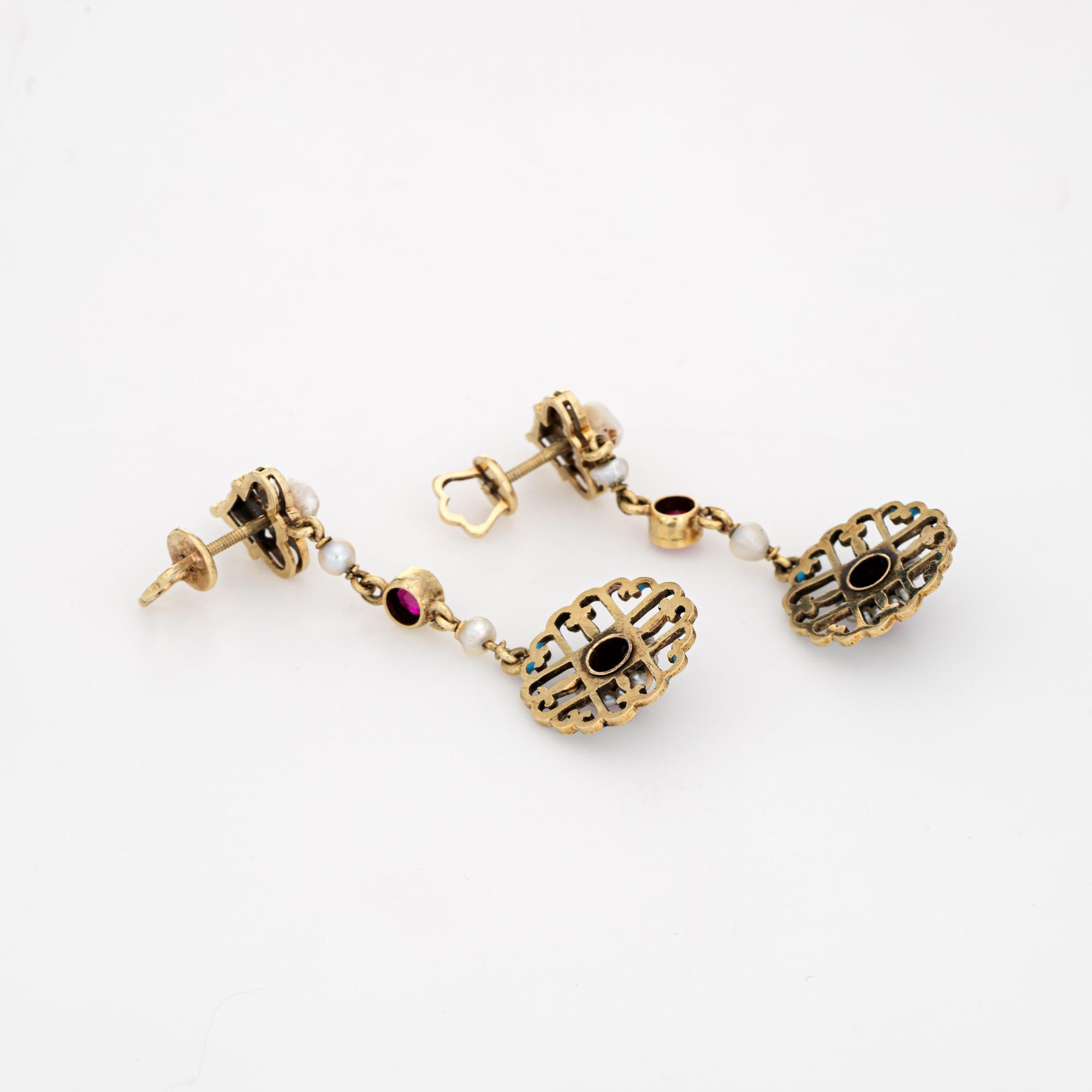Elegant and finely detailed Edwardian era enamel earrings (circa 1900s to 1910s), crafted in 14 karat yellow gold.  

Created rubies graduate in size from 3.5mm to 4mm (in very good condition and free of cracks or chips). Small natural 1mm seed