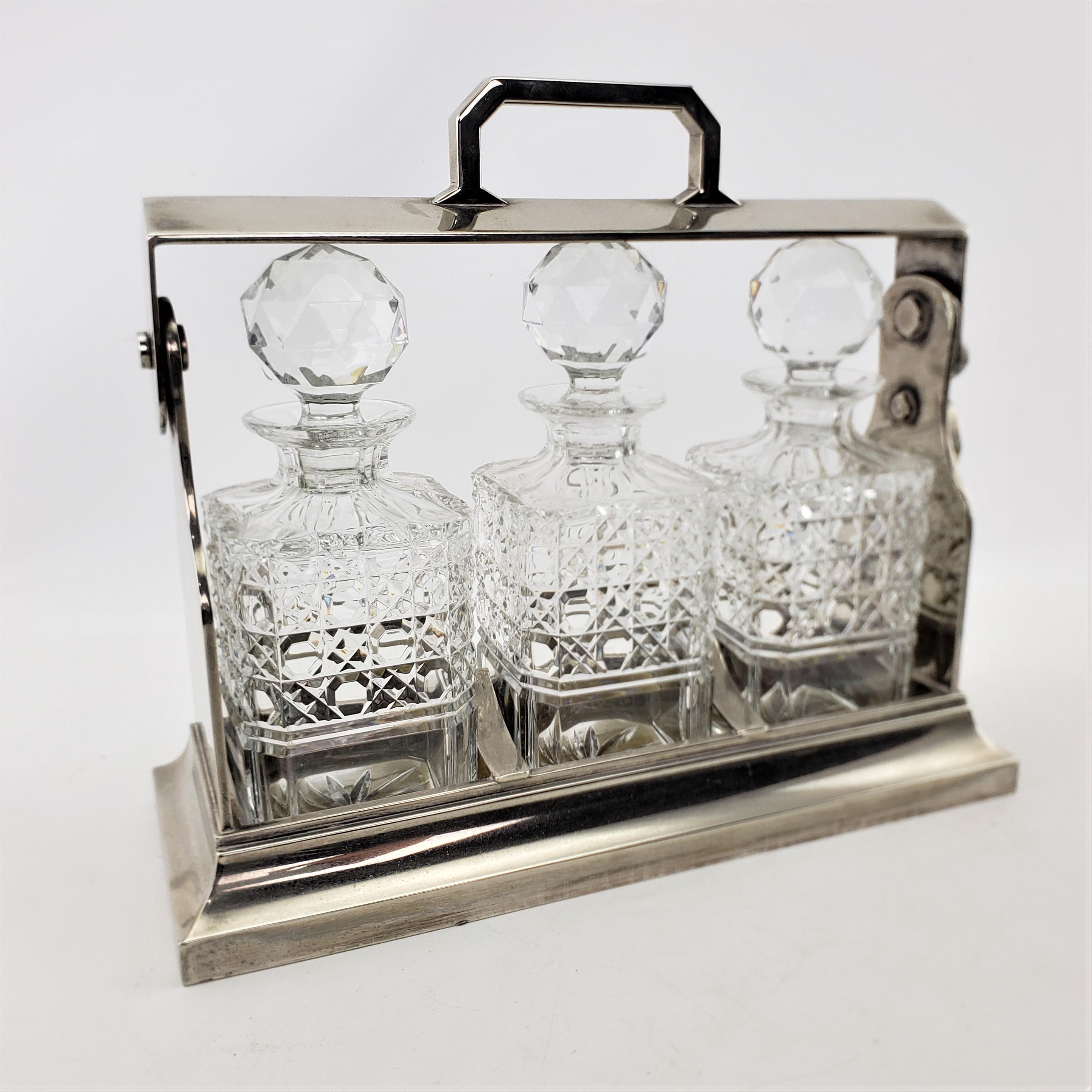 This silver plated three bottle tantalus has no maker's marks, but is presumed to have originated from England and date to approximately 1900 and done in the period Edwardian style. The tantalus is composed of silver plate with a sturdy locking