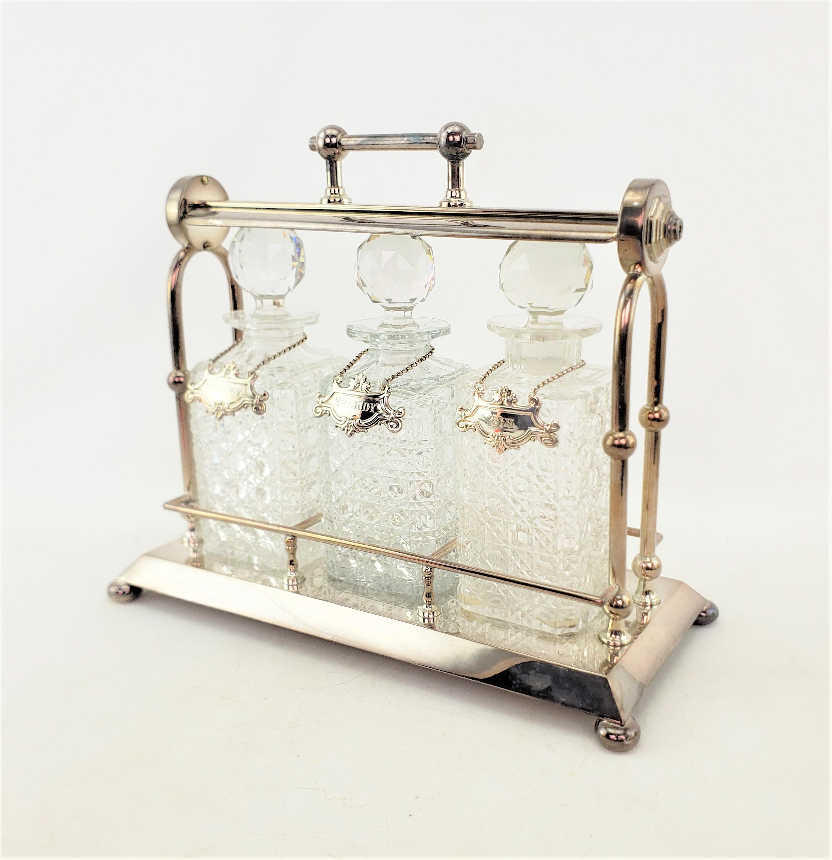This silver plated three bottle tantalus has no maker's marks, but is presumed to have originated from England and date to approximately 1900 and done in the period Edwardian style. The tantalus is composed of silver plate with a sturdy locking