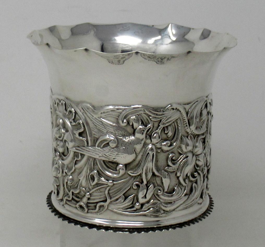 A superb and quite rare example of a Edwardian Chased and Embossed  wine or champagne bottle coaster of small size. 

With all-round lavish decoration depicting scrolling leaves and flowers with swallows below a plain wavy rim. 

Condition: Superb