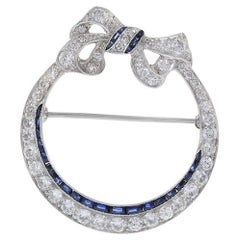 Antique Edwardian Era Platinum Sapphire and Diamond Circle Bow Lapel Pin
