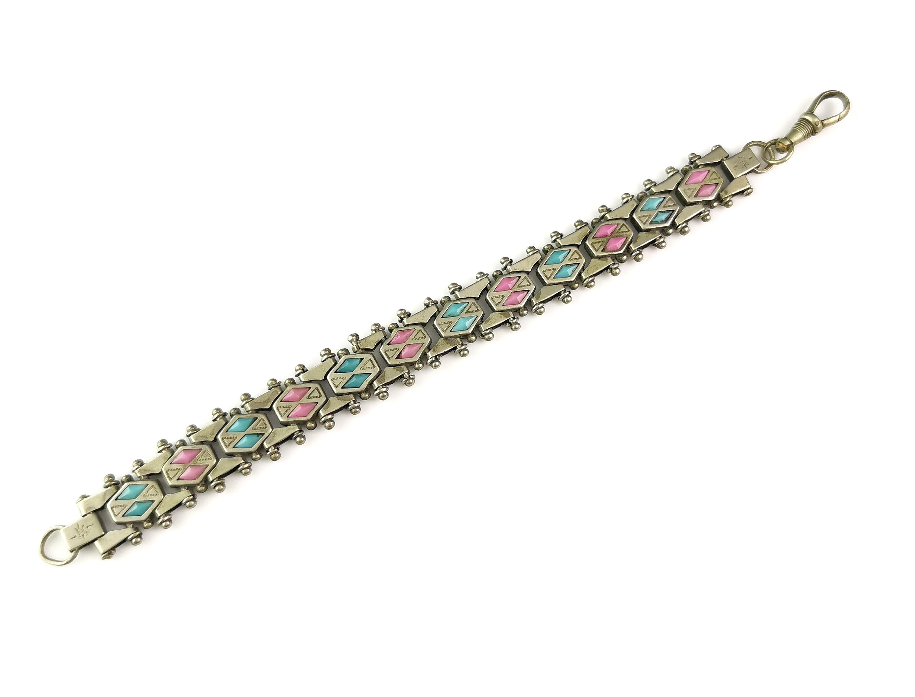 A gorgeous and unusual antique fancy link bracelet.

It is quite a chunky bracelet with fancy book chain style links each intercepted with baby pink and blue paste.

The light pastel shades contrast well with the chunky links.

It fastens with a dog