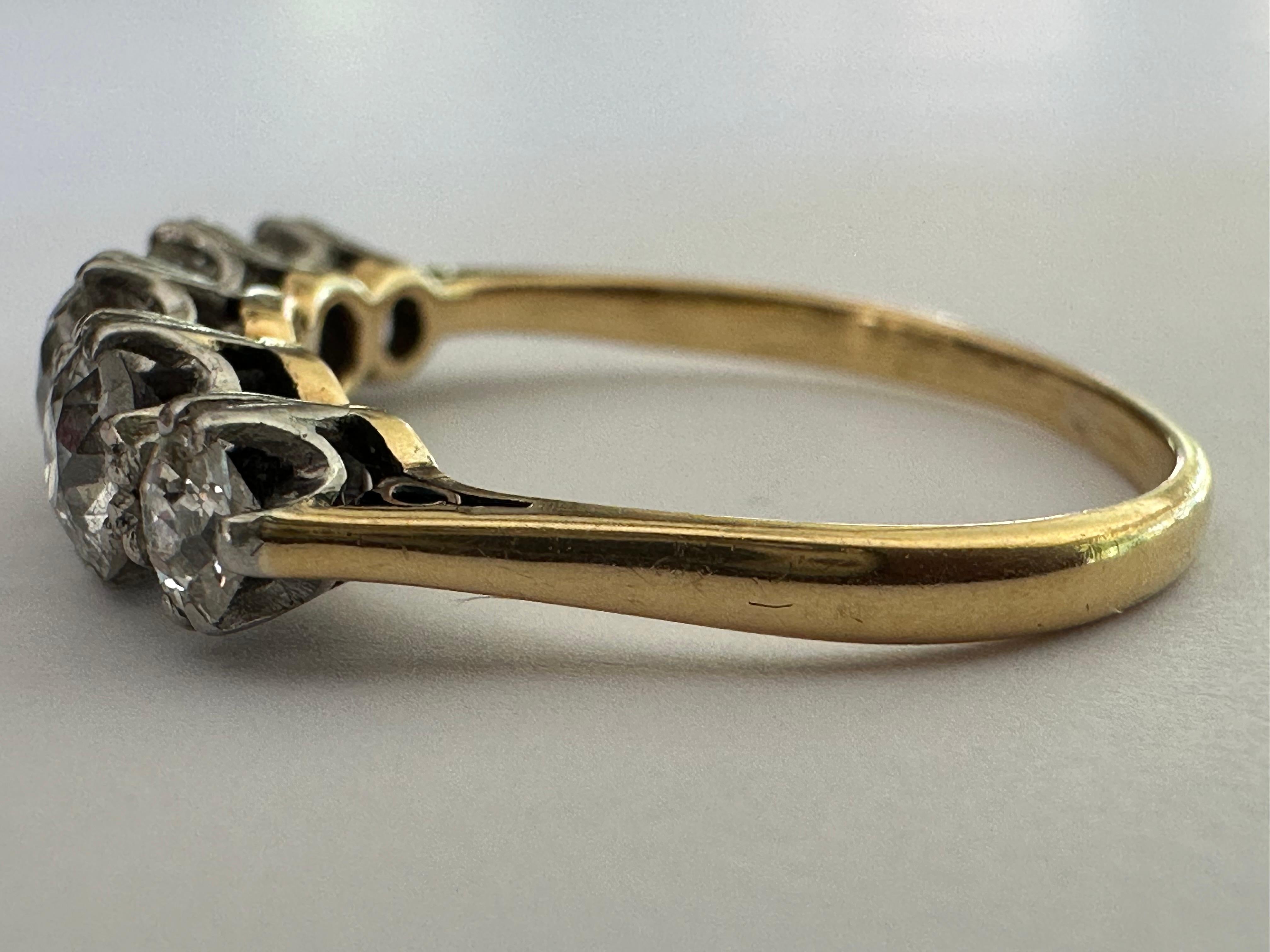 Crafted in the early 1900s, this Edwardian era band is designed around five Old European-cut diamonds together totaling approximately 1.35 carats, HJ color SI1-2 clarity. Set in two-tone 18K white and yellow gold with European hallmarks. 
