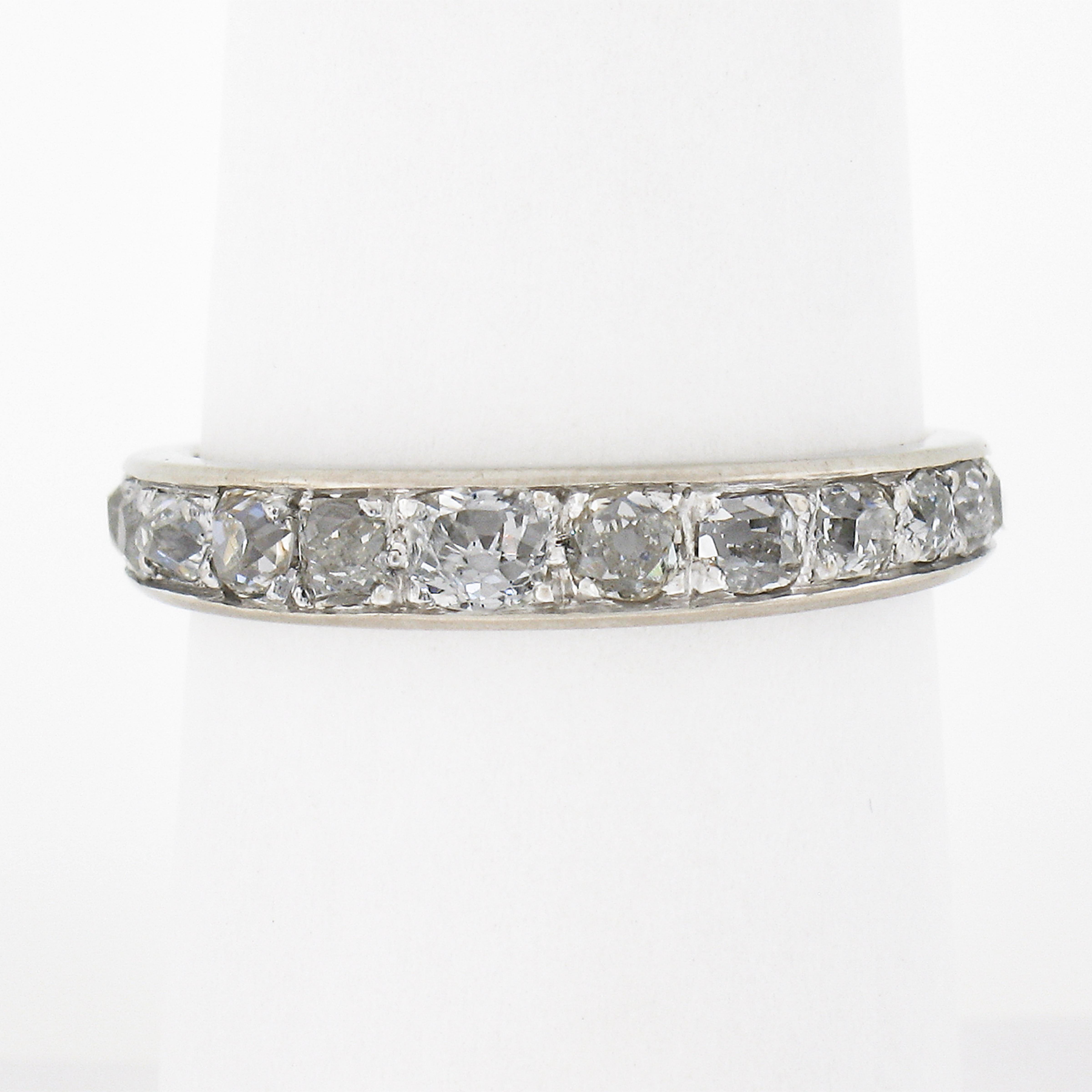 This gorgeous antique diamond eternity band ring was crafted in France from solid 18k white gold during the Edwardian period. It features a simply beautiful design that carries fine and fiery old mine and old rose cut diamonds that graduate in size