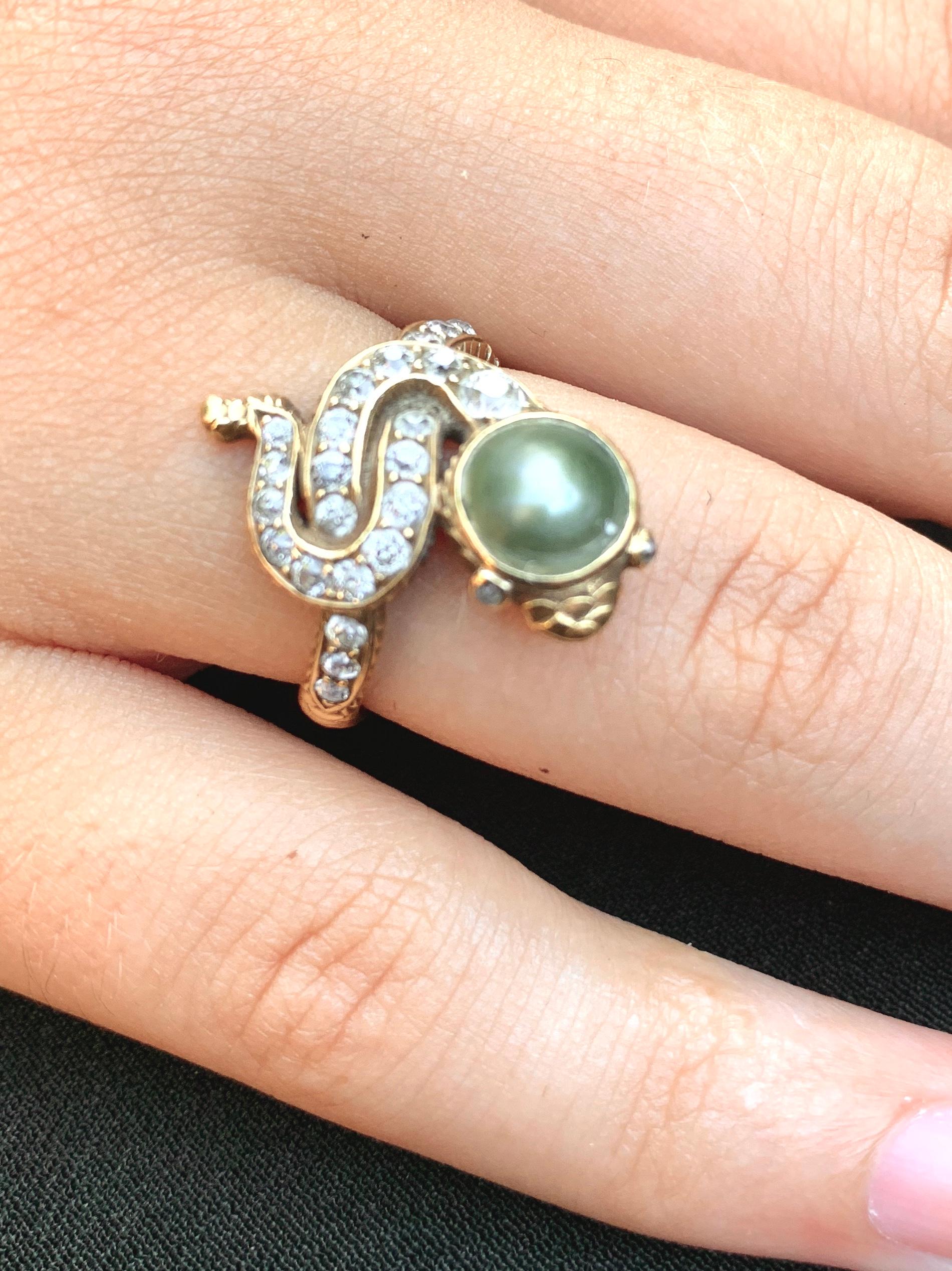 Rare antique Edwardian period fine natural pearl, diamond and 18K yellow gold snake ring
Early 20th Century
Featuring a dramatic lustrous natural deep grey pearl 6.5mm in diameter with fine quality F-G diamonds, approximately .70 TCW 
The snake with