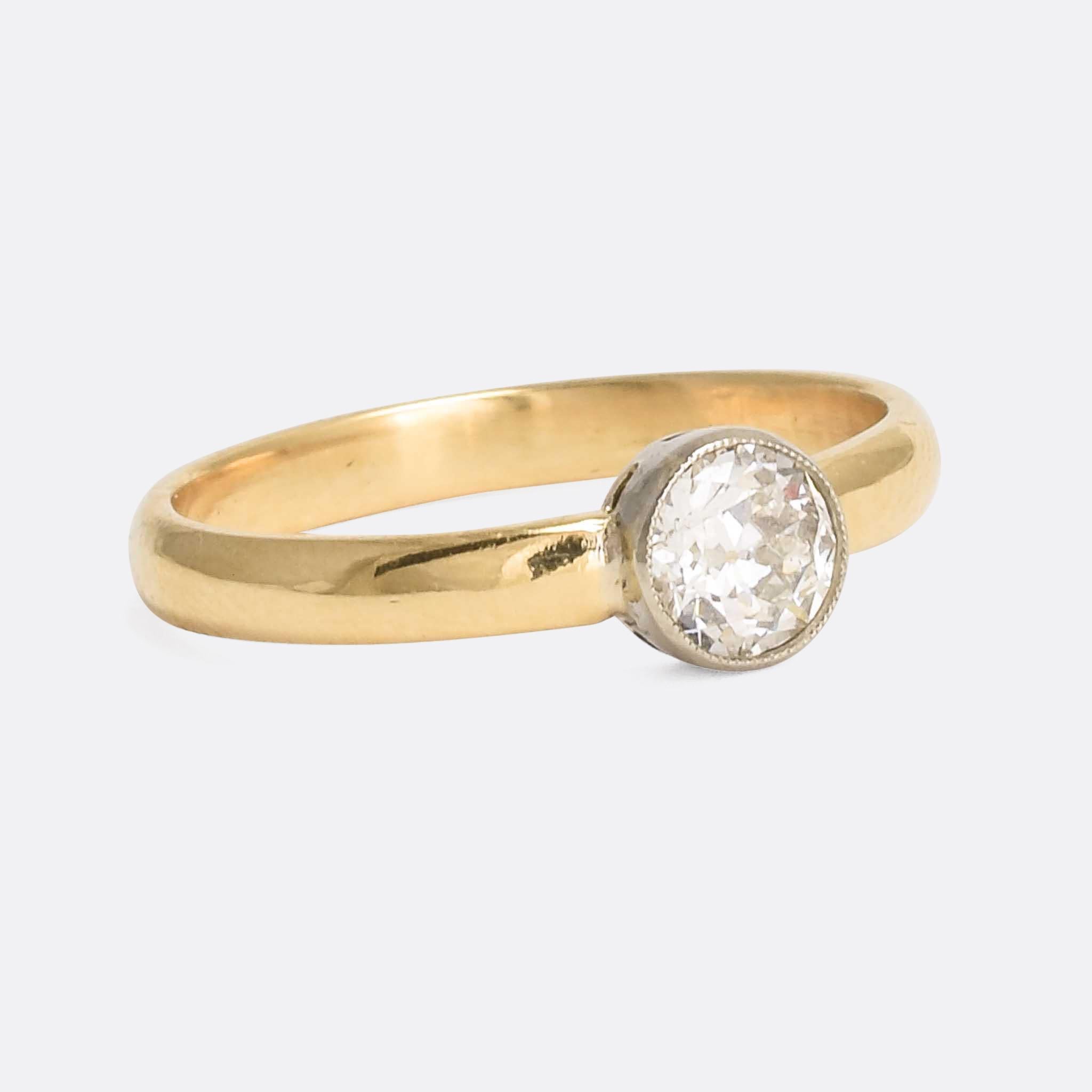 A sleek and simple diamond solitaire ring dating from the Edwardian era. The stone is a beautiful .50ct old European cut diamond; it rests in a simple millegrain collet setting, with excellent colour and clarity grades. Modelled in 18k gold and