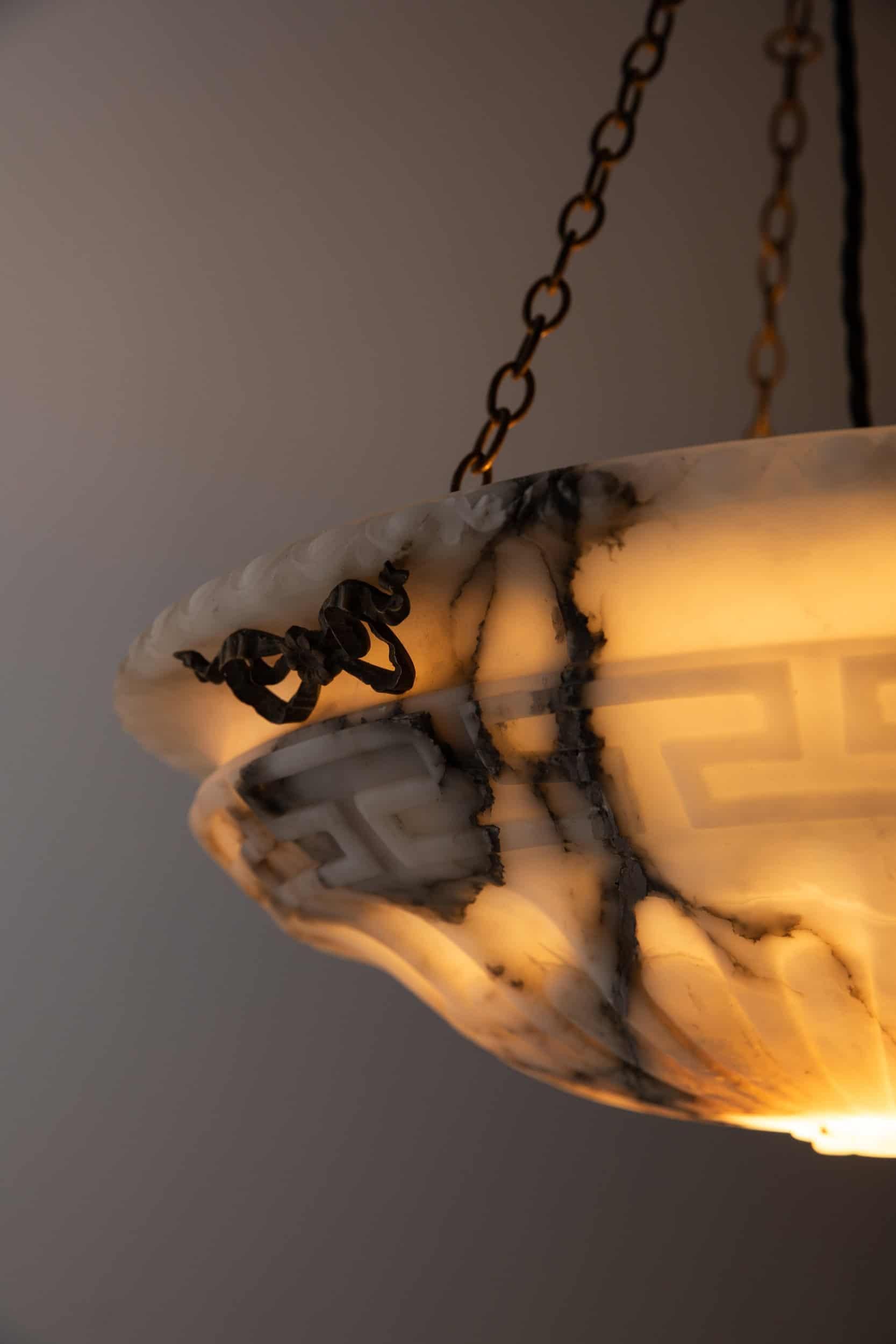 

An incredibly elegant carved alabaster plafonnier pendant light. c.1900

White alabaster with a beautiful array of dark marbling. Hand carved decorative details including egg and dart edging with Greek key and floral motifs. Complete with brass