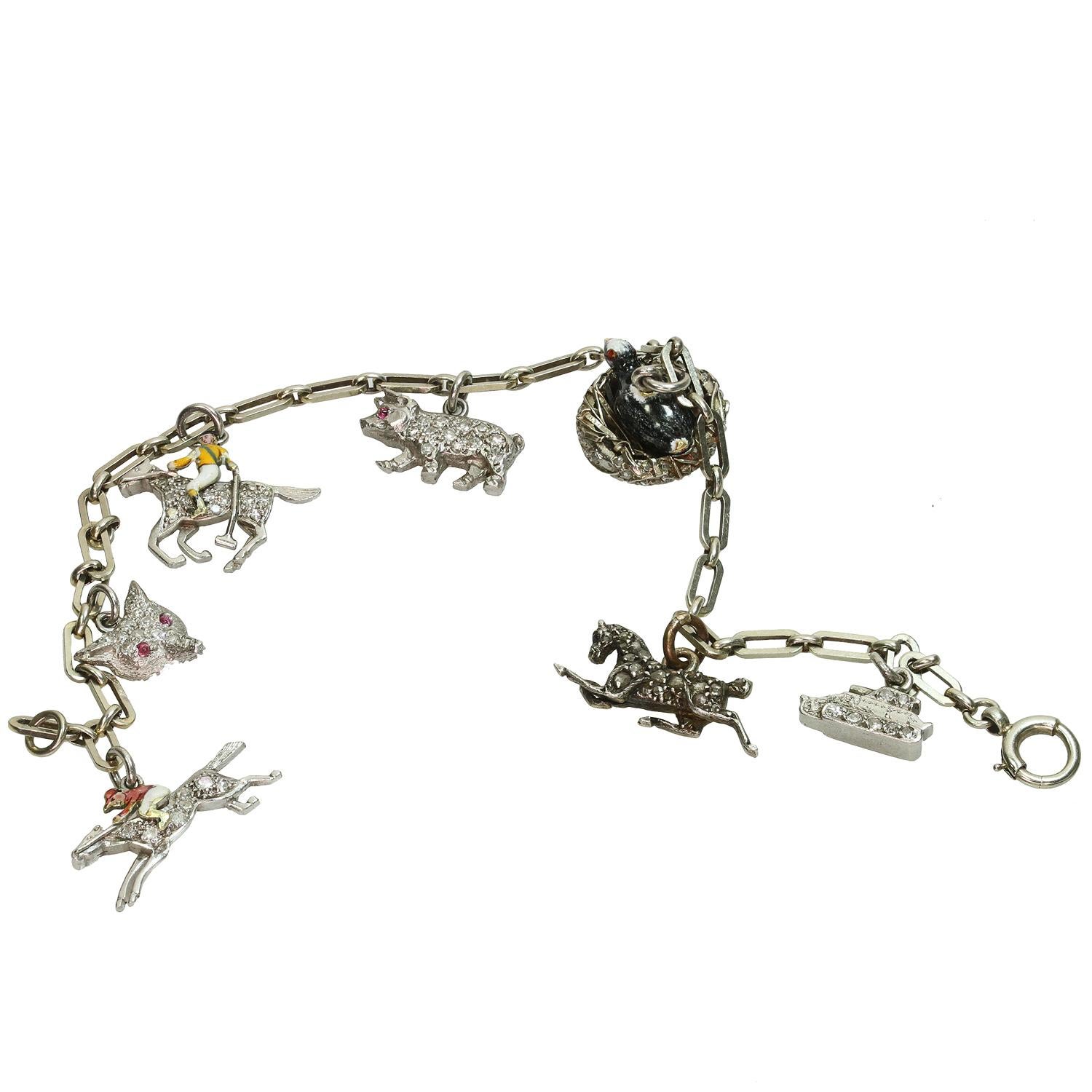 This antique hand-made link bracelet is crafted out of 9k white gold and features a total of 7 amazingly unique charms - two equestrians, a tank, a fox, a pig, a horse, a bird in a nest. Six charms are made of platinum while the horse charm is made