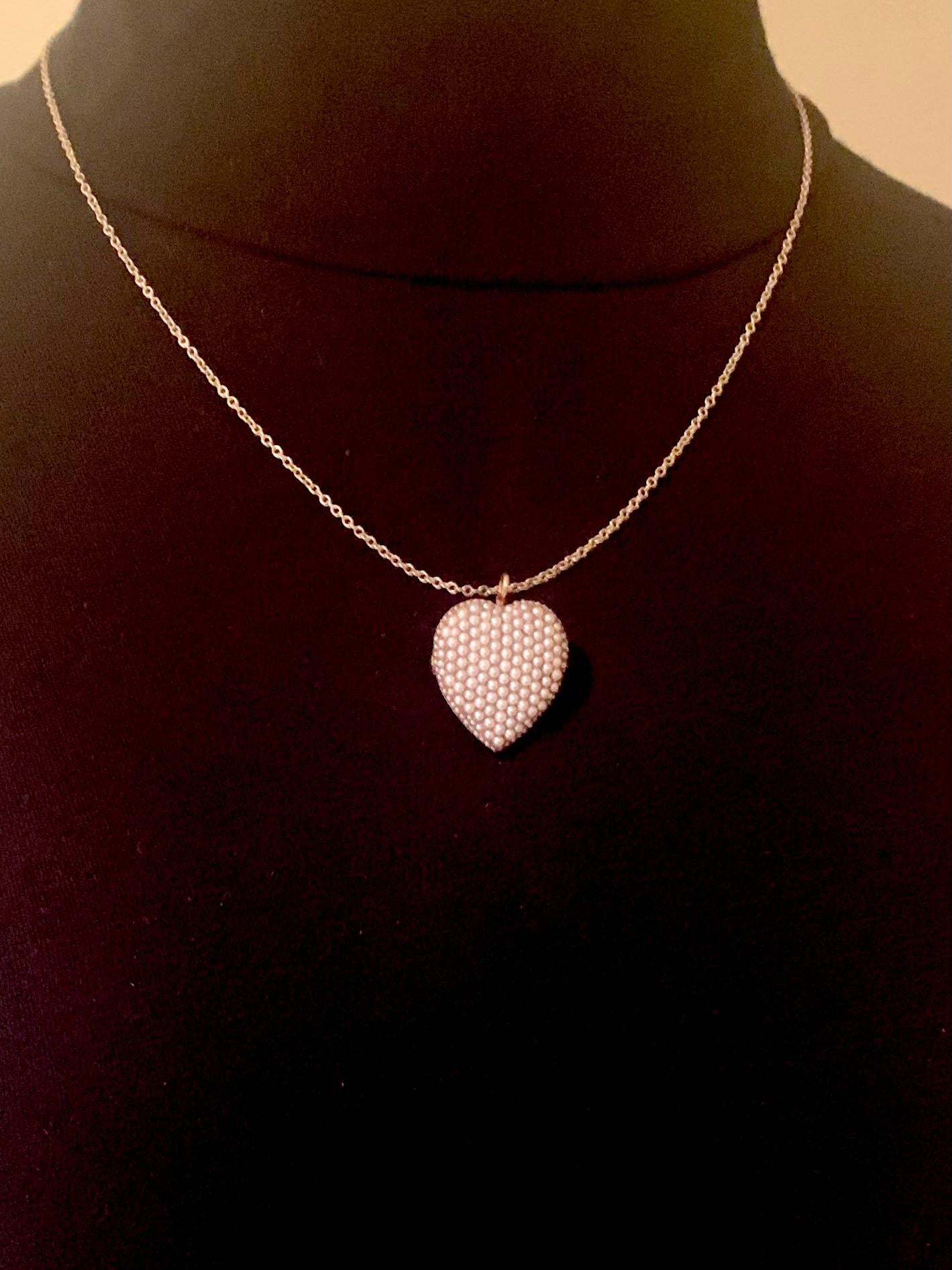 Classic, elegant antique Edwardian Riker Brothers natural pearl and 14K yellow gold heart shaped pendant/brooch
Early 20th Century
A timeless symbol of love, designed as a slightly rounded heart set with natural 1mm to 2mm seed pearls of beautiful
