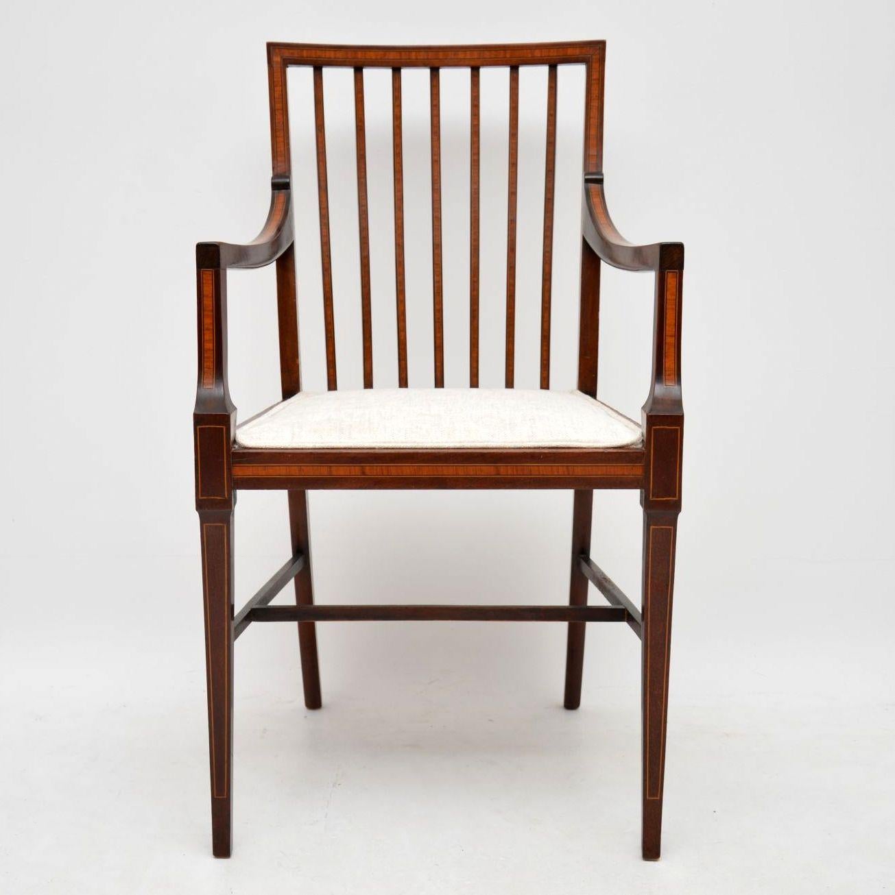 This fine quality elegant armchair has a high seat height so would be ideal as a desk chair. It's antique Edwardian and mahogany with satinwood inlaid bandings. The satinwood inlays are in many places, all over the back, arms, legs, across the seat