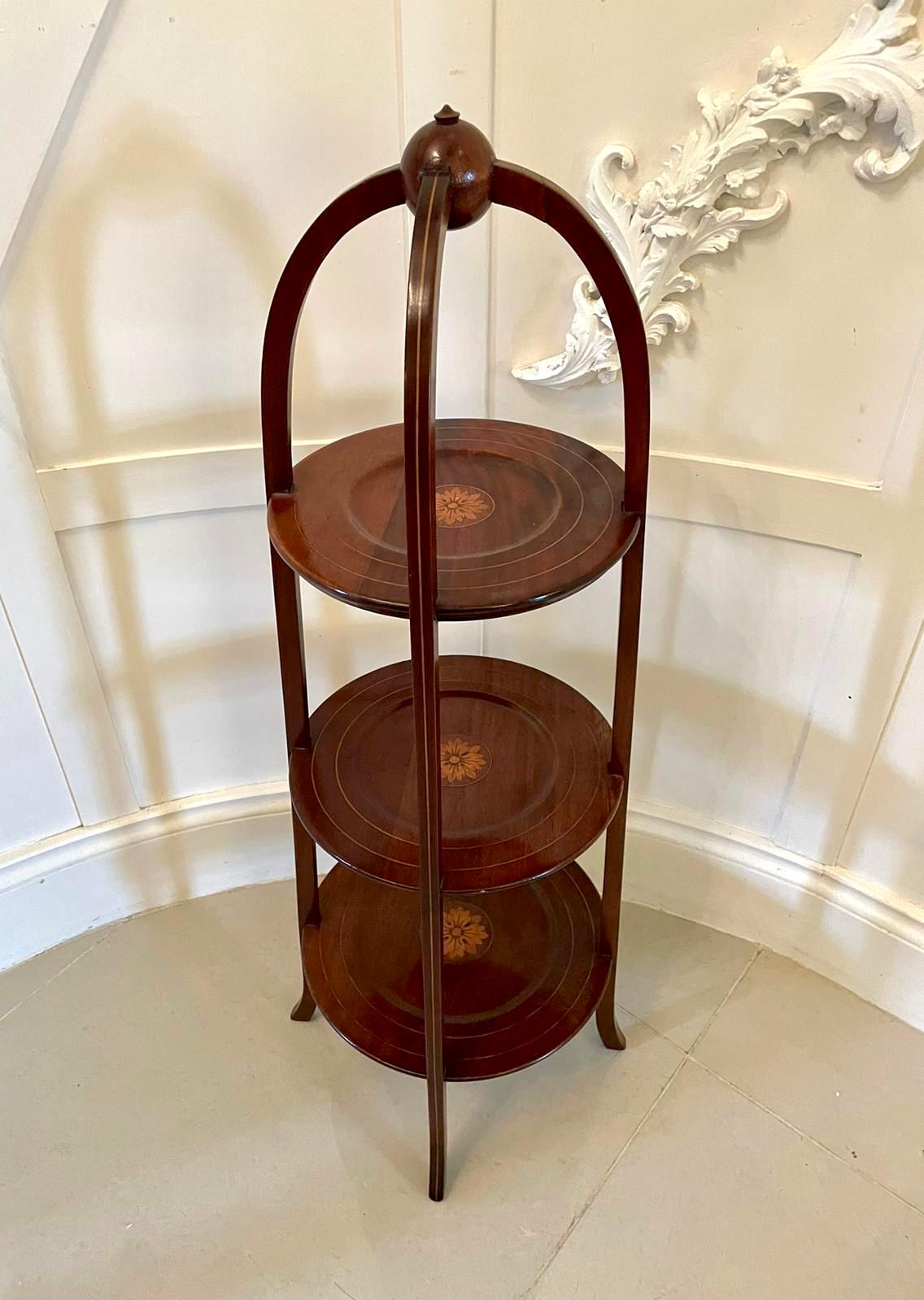 Antique Edwardian inlaid mahogany cake stand having three graduated circular dishes with pretty satinwood inlaid flower heads with a round mahogany handle to the top and supported by three inlaid mahogany legs.

A quality example in lovely