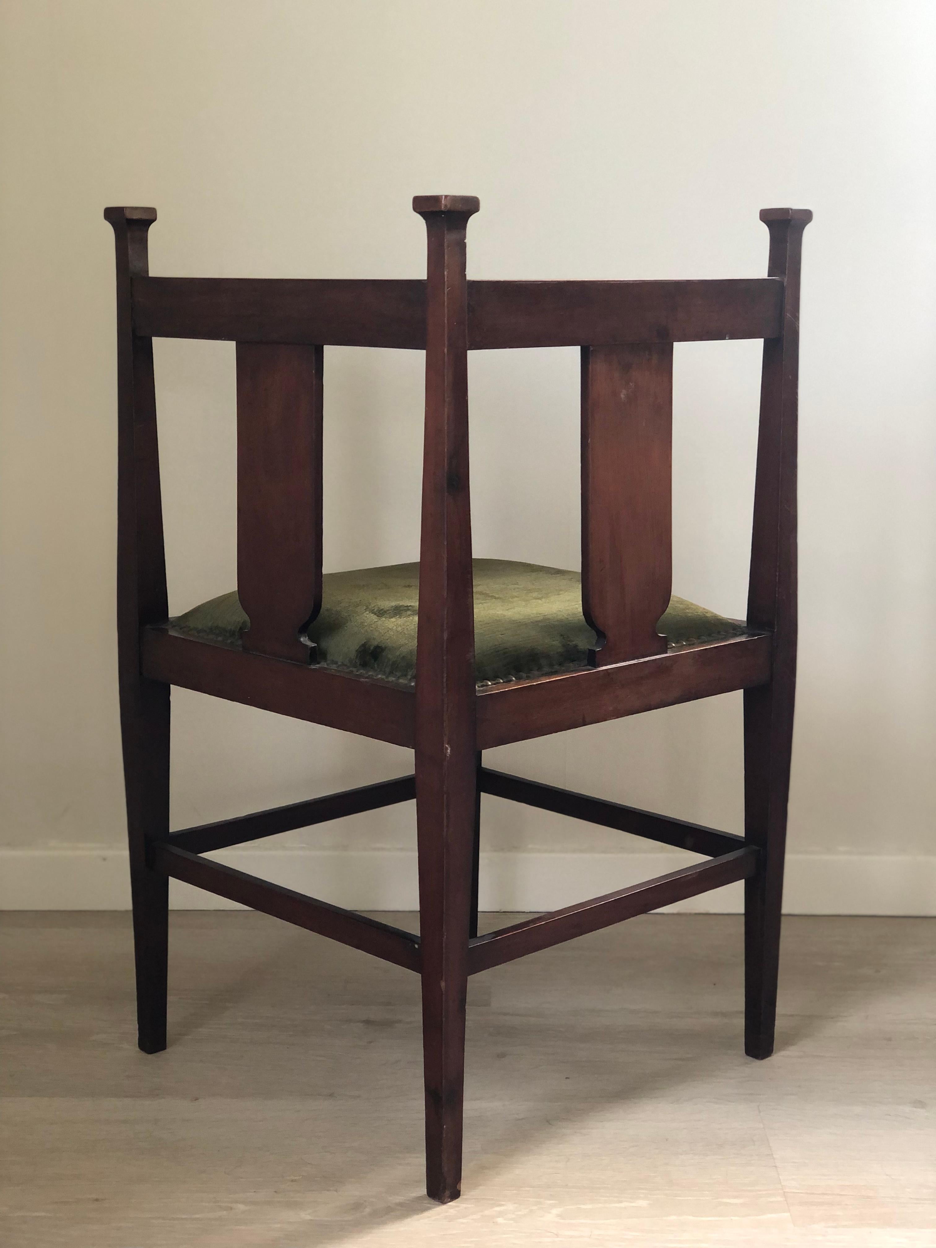This elegant Edwardian chair, crafted in the early 20th century, is made from mahogany and features fine satinwood inlays. A delicate floral motif is cut out in the center and filled with satinwood, showcasing the refined craftsmanship of the
