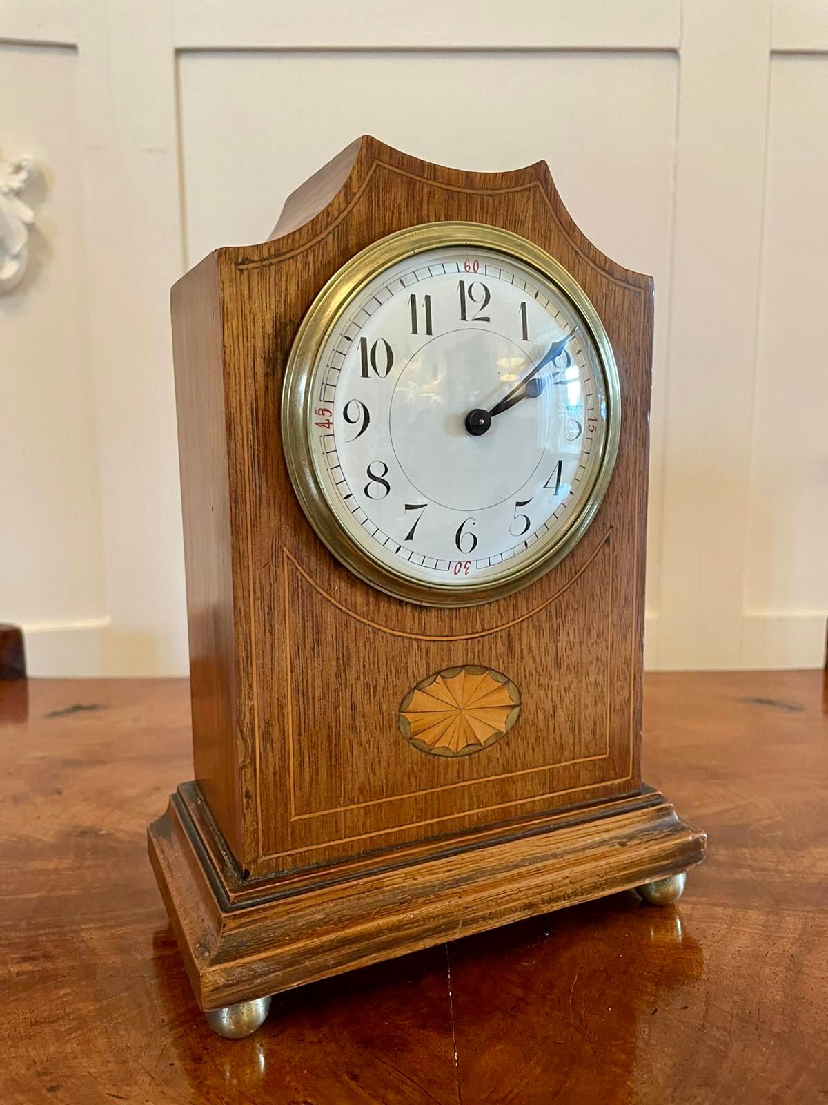 Antique Edwardian inlaid mahogany eight day mantel clock having a pretty shaped top mahogany case inlaid with boxwood stringing and an oval satinwood shell, enamel dial with original hands, brass beze. It stands on a shaped plinth with original