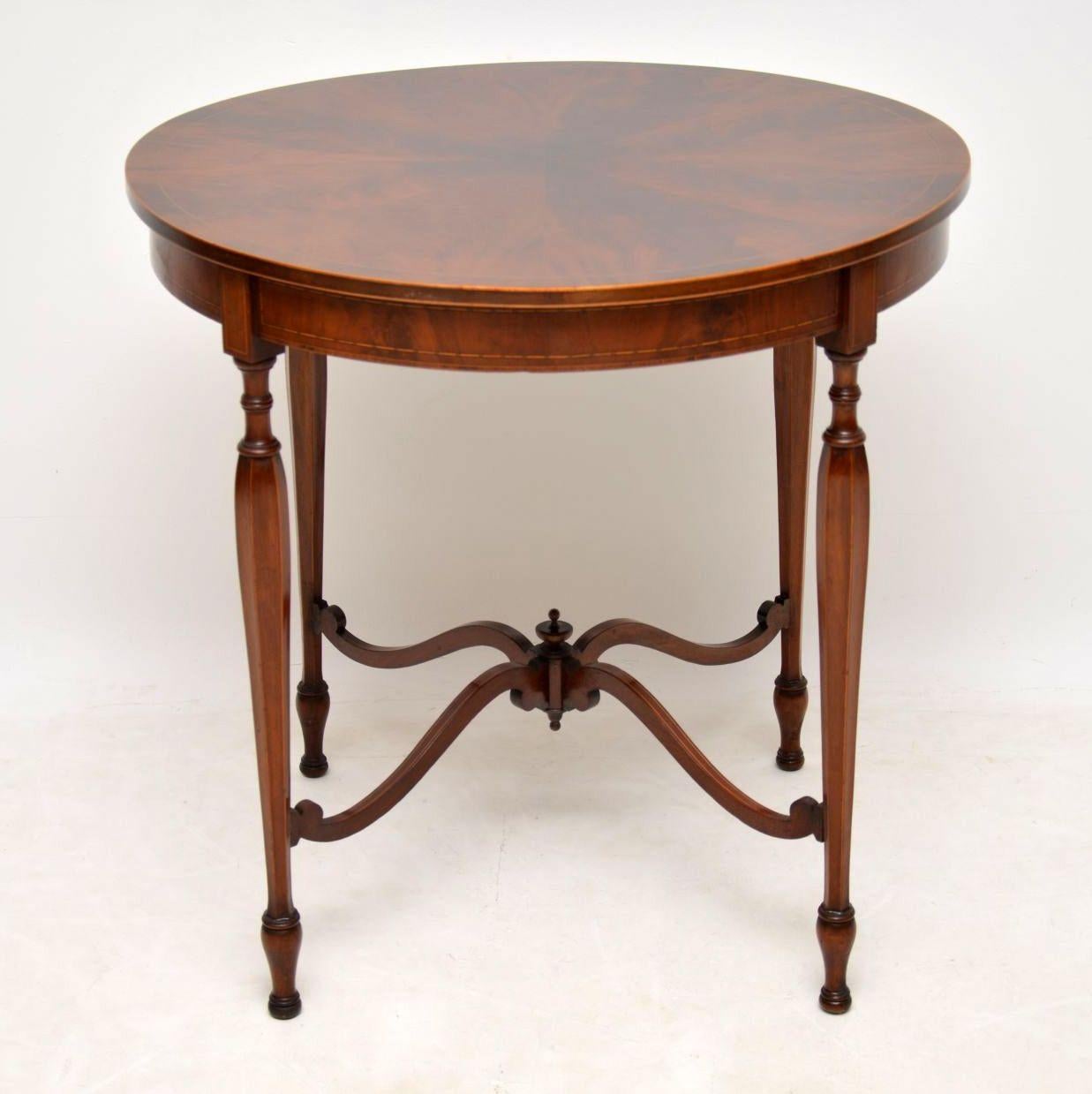 This mahogany table is fabulous quality and is in excellent original condition, with some fine details. It's antique Edwardian, dating from the 1890-1910 period. The top is spectacular and made up of segmented flame mahogany veneers, with fine