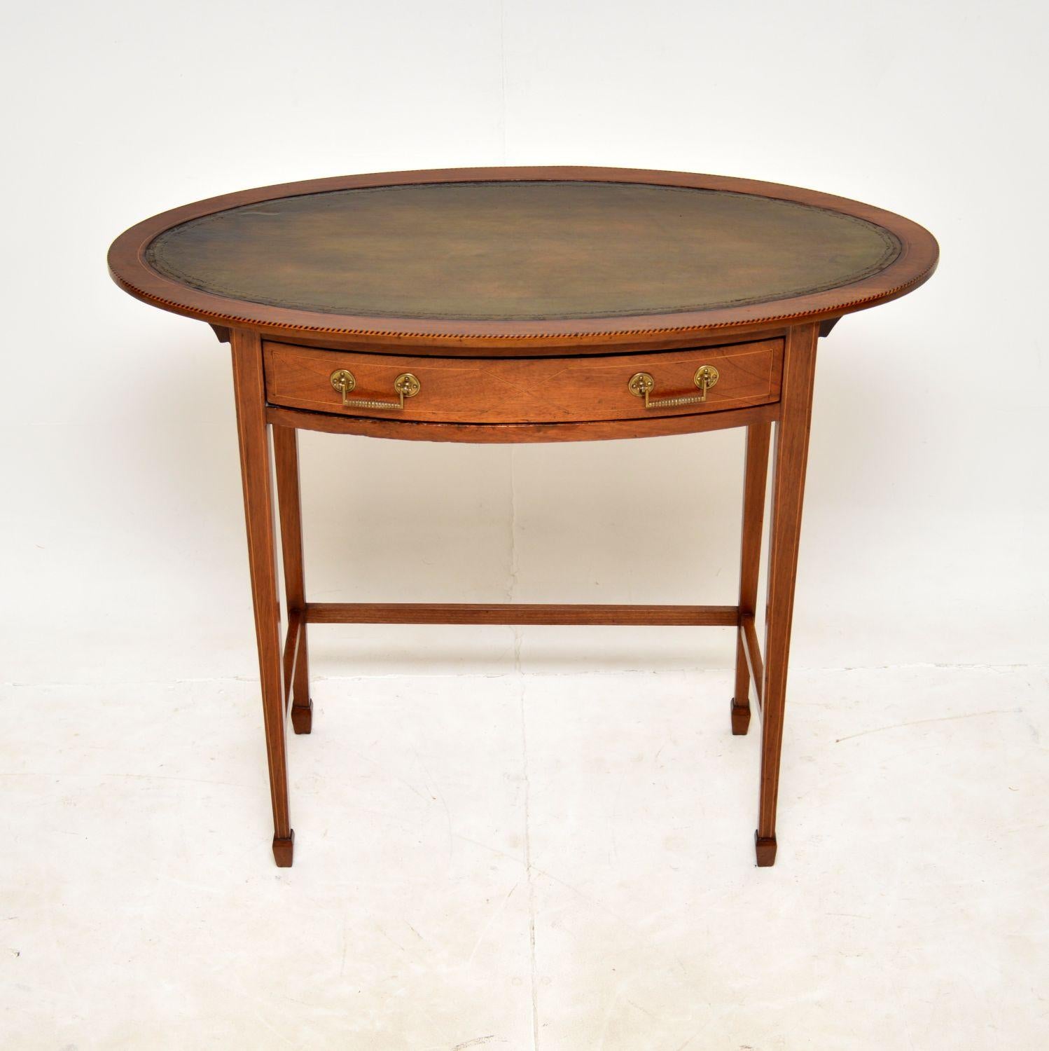 A beautiful and quite unusual antique Edwardian leather top writing table. This was made in England, it dates from around 1890-1900.

This is very well made and is a useful size, the oval top has an inset tooled green leather writing surface. There