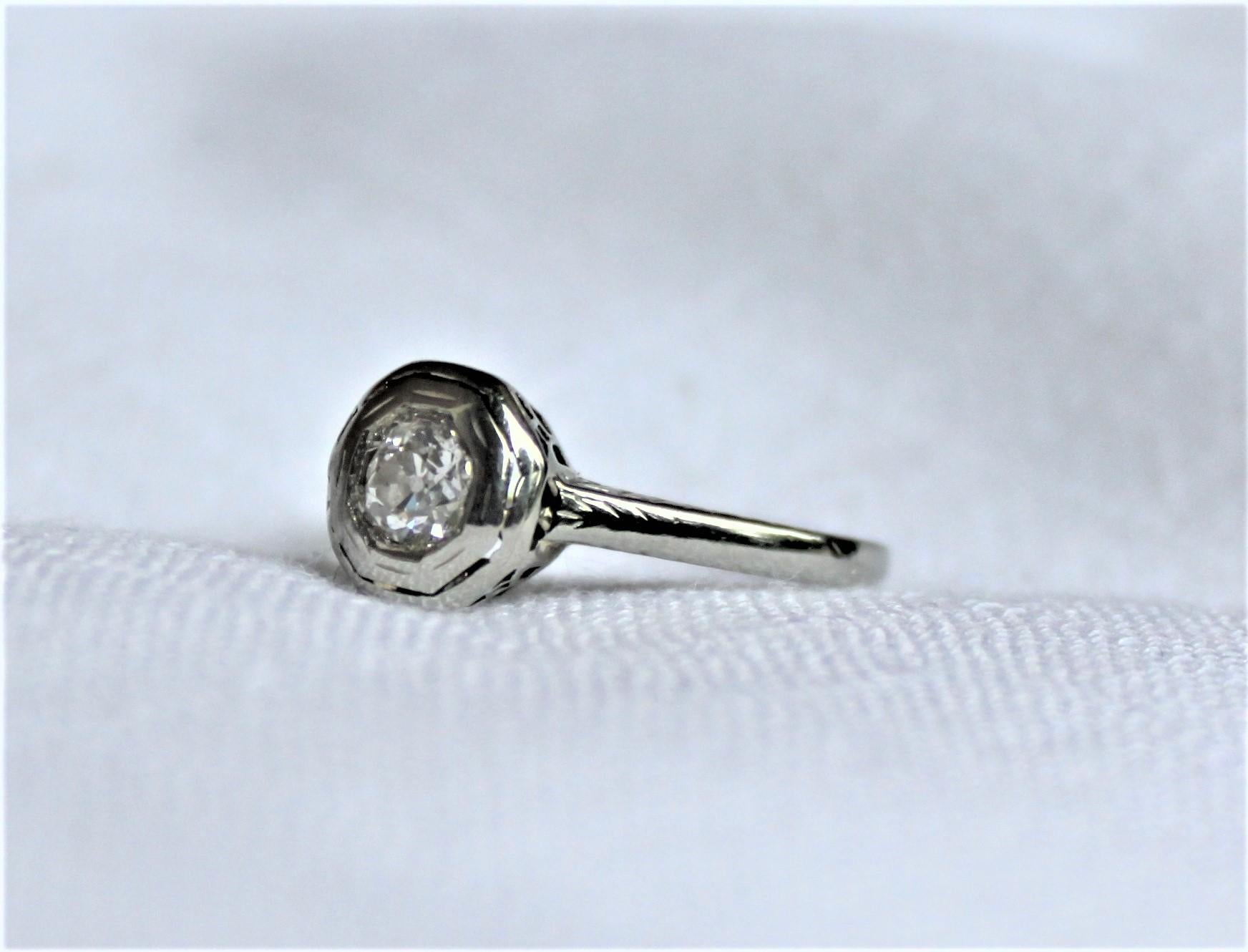This antique 18-karat white gold and diamond ring dates to circa 1900 and presumed to have been made in the United States. The diamond is an old European style cut and bead set and has an approximate weight of a quarter ct. This solitaire diamond is