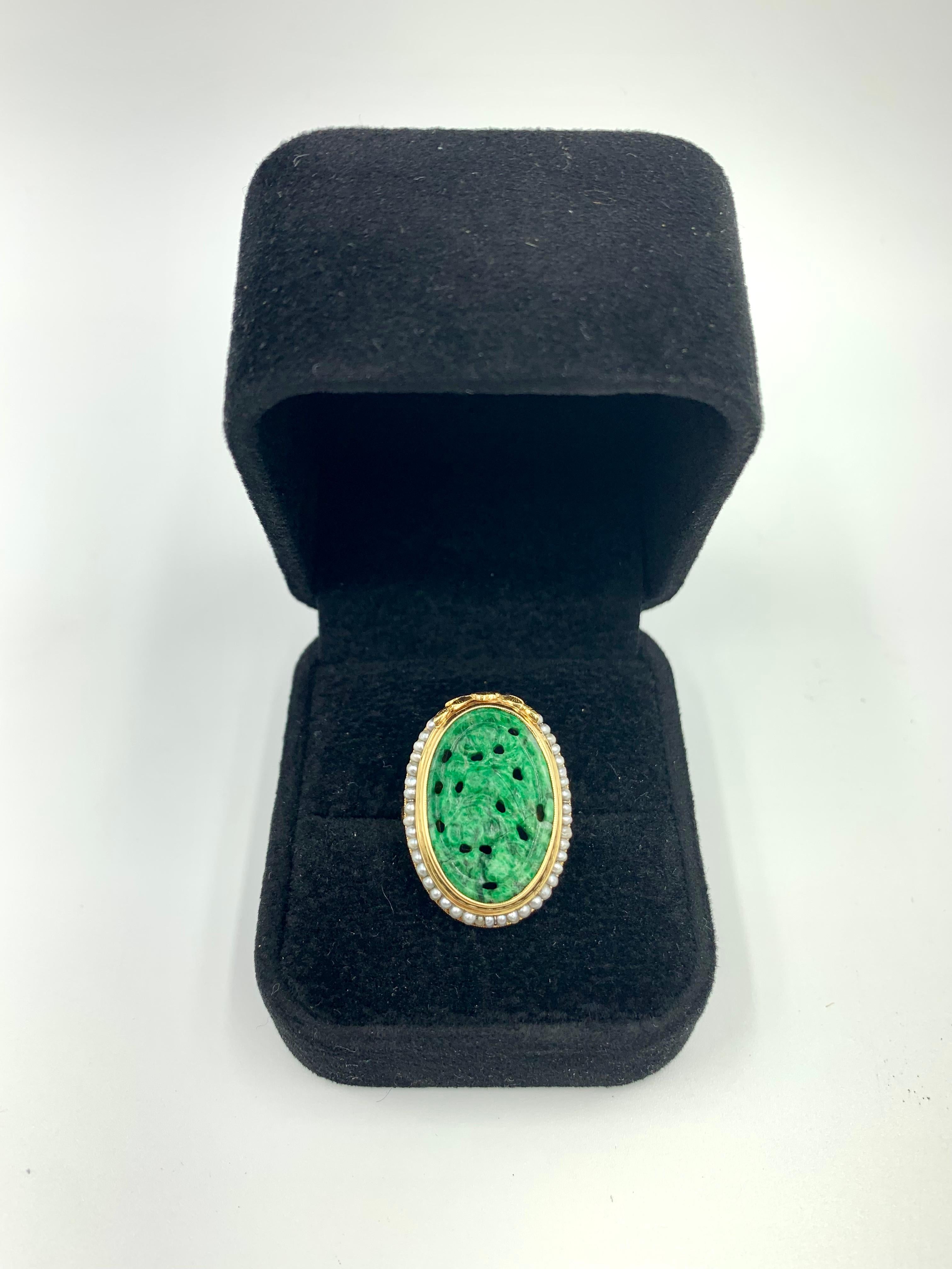 Fine antique Edwardian period natural carved reticulated apple green Chinese jade ring with a Laurel leaf gold crest surrounded by natural seed pearls and a beautifully engraved 14K gold setting. The jade is apple green with lovely deep forest green