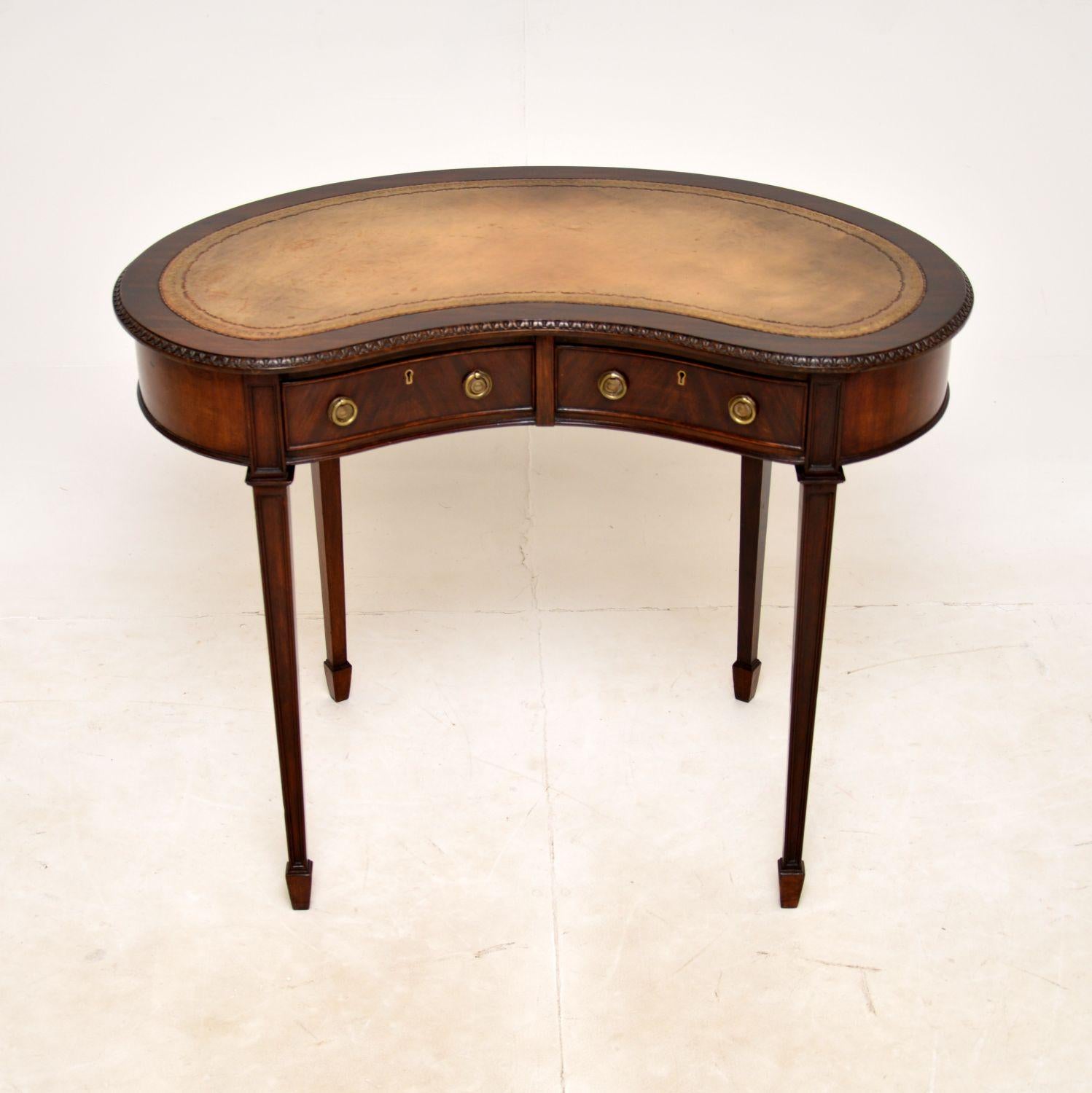 A superb antique Edwardian kidney shaped desk. This was made in England, it dates from around 1900-1910.

The quality is outstanding, this sits on beautifully tapered legs terminating in spade end feet. The kidney shaped top has lovely carving