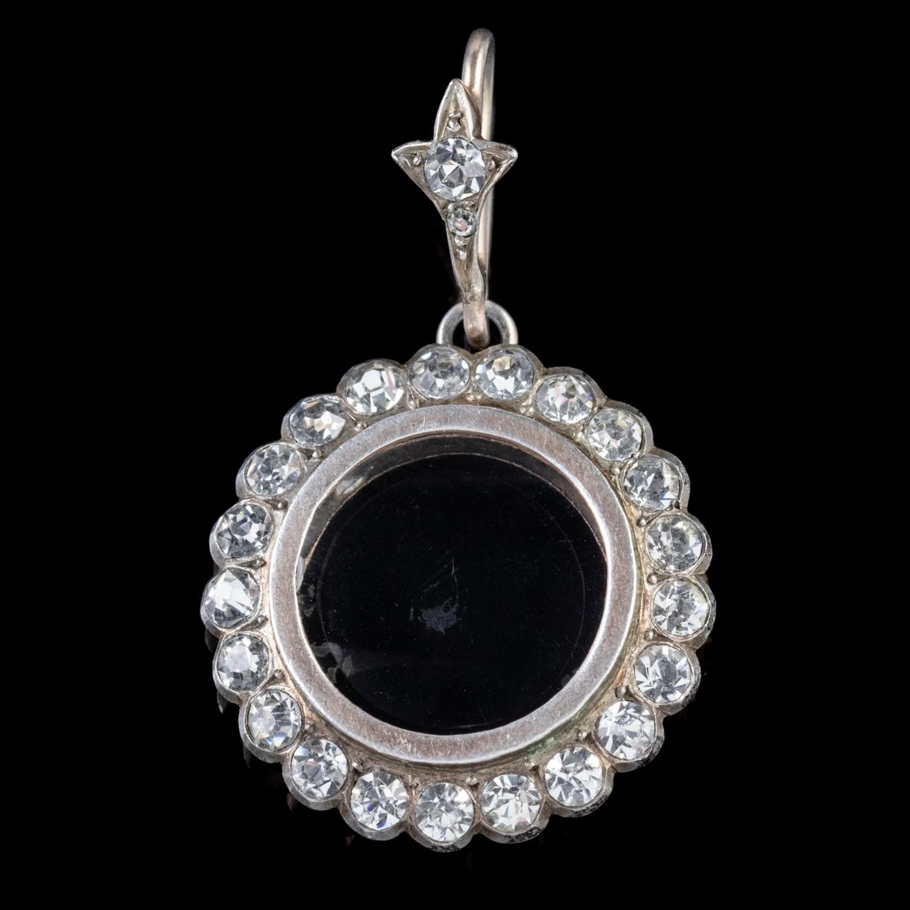 This beautiful antique Edwardian locket is modelled in Silver and features a central window haloed by lovely sparkling Paste Stones. 

Paste is a transparent flint glass that simulates the fire and brilliance of gemstones. White Pastes sparkle just