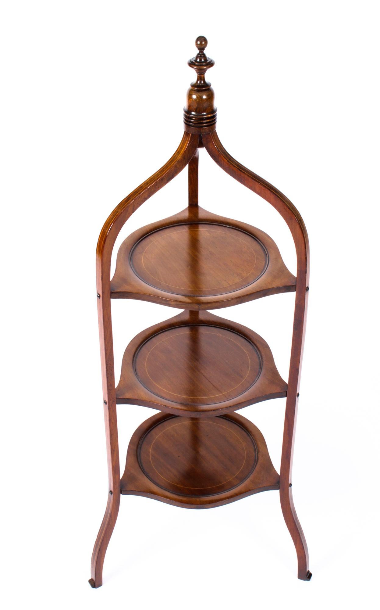 This is a beautiful antique Edwardian three tier mahogany cake stand, circa 1900.

The stand is exquisitely crafted in mahogany, is surmounted by an elegant turned finial, has three shaped uprights with three dished tiers, and features boxwood