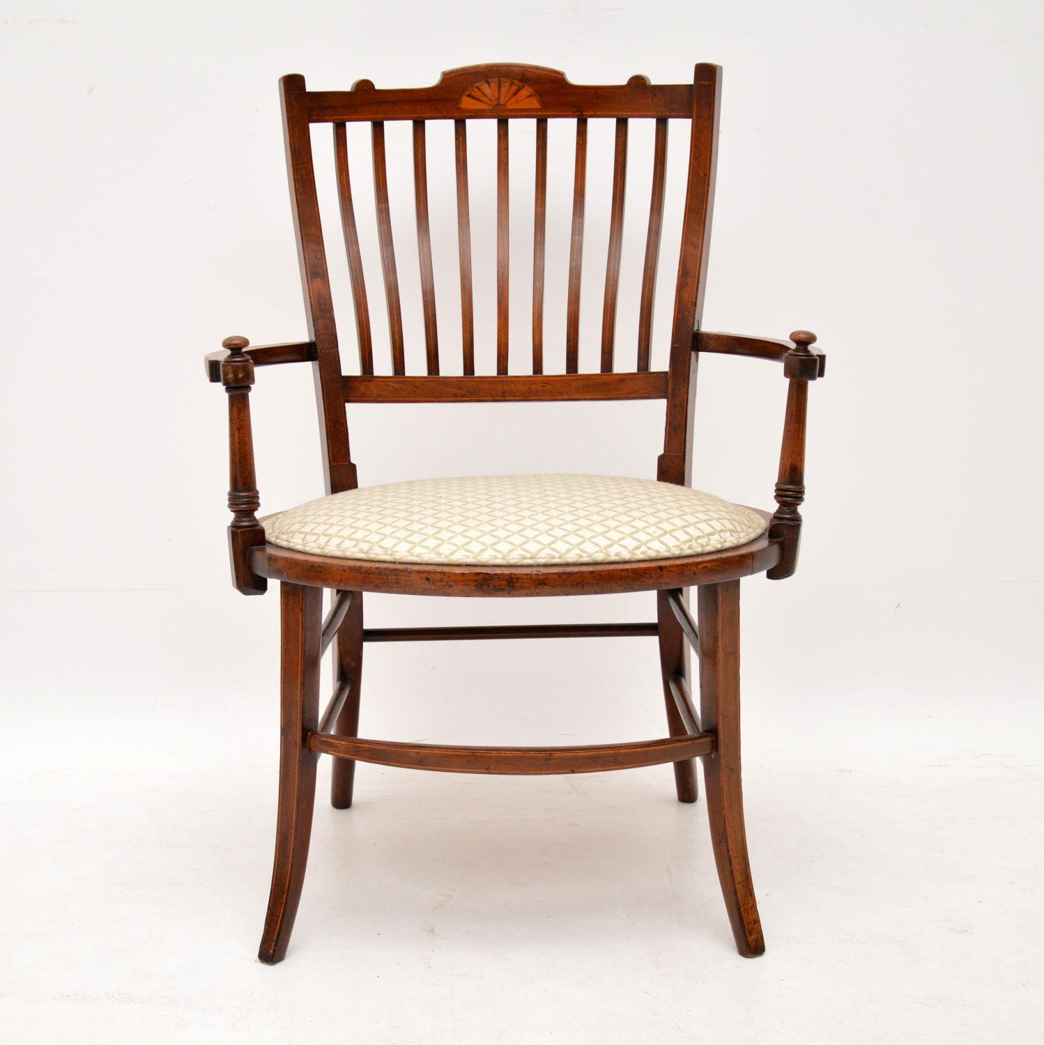 This antique Edwardian inlaid mahogany armchair is in lovely original condition. It’s been gently polished and we have left the seat as is, because it’s in good condition too, but not new. The frame is of strong construction, with many cross