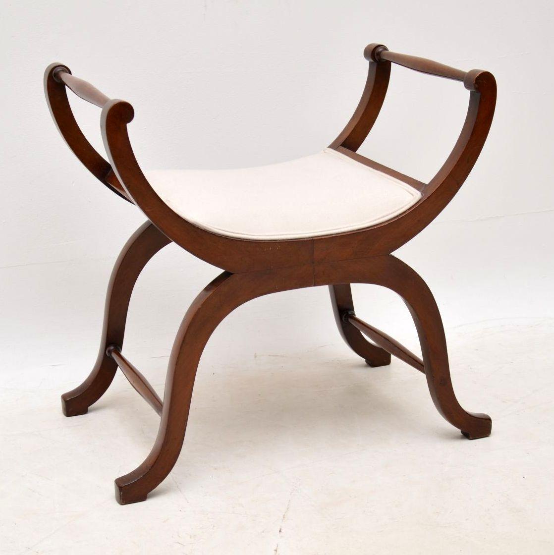 Antique Edwardian mahogany gondola stool in good original condition and with a lovely shape. This stool would be ideal for use with a dressing table. It has turned rails at the top & matching turned stretchers between the legs to give more