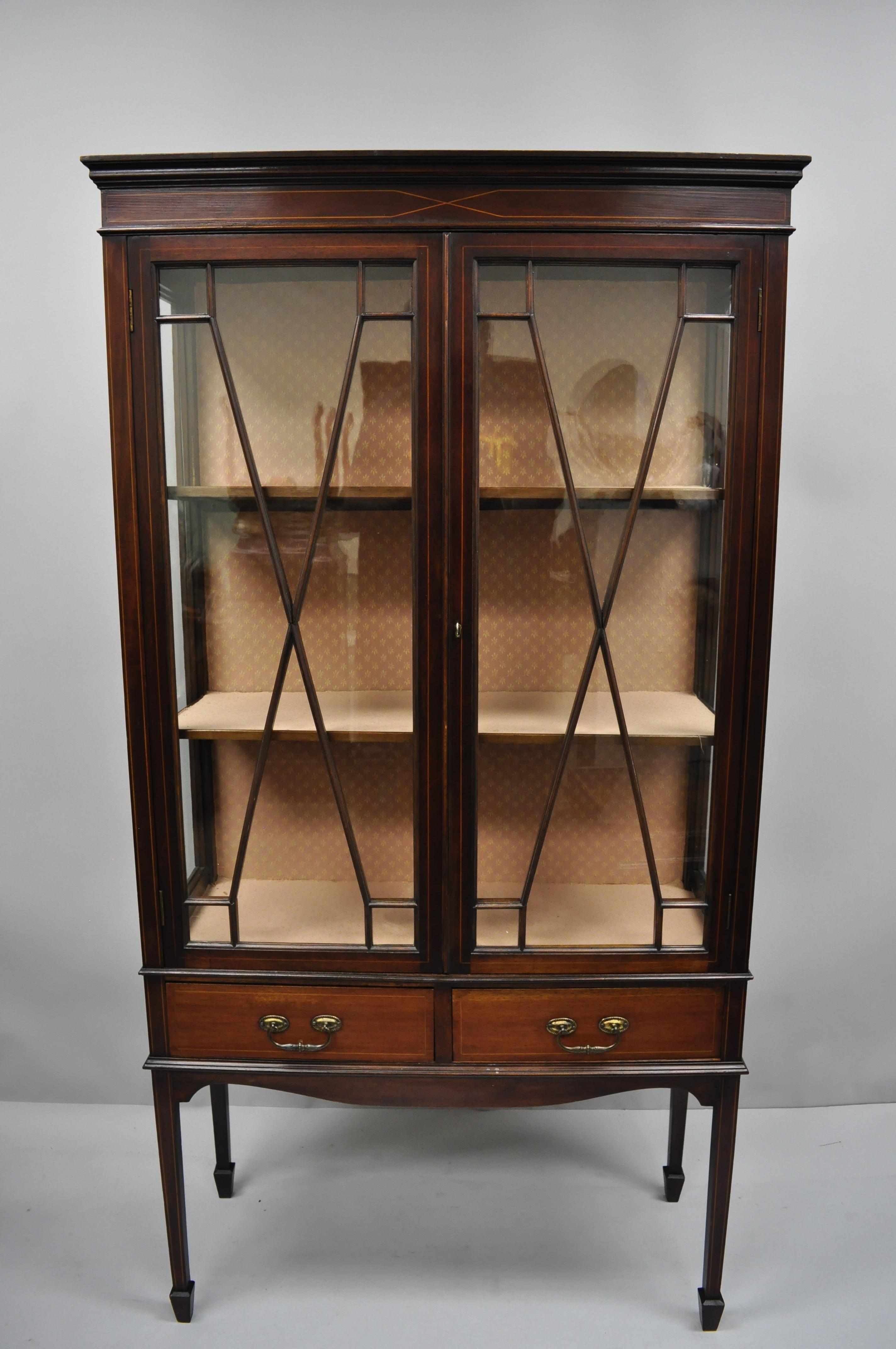 Antique mahogany English Edwardian inlaid two-door Curio China cabinet. Item features individual panes of glass, glass sides, fabric lined lighted interior, two glass swing doors, two hand dovetailed drawers, working lock and key, tall tapered legs,