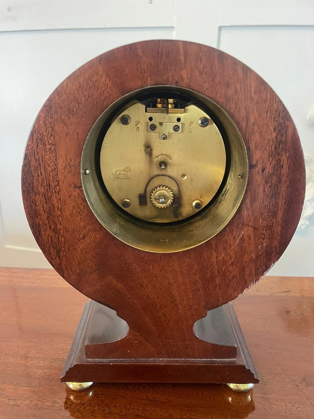 Fino reloj de sobremesa de caoba con incrustaciones de la época eduardiana, con una bonita caja de marquetería en forma de globo con patas de bola de latón originales. Una elegante esfera esmaltada con agujas originales y un movimiento de 8 días.