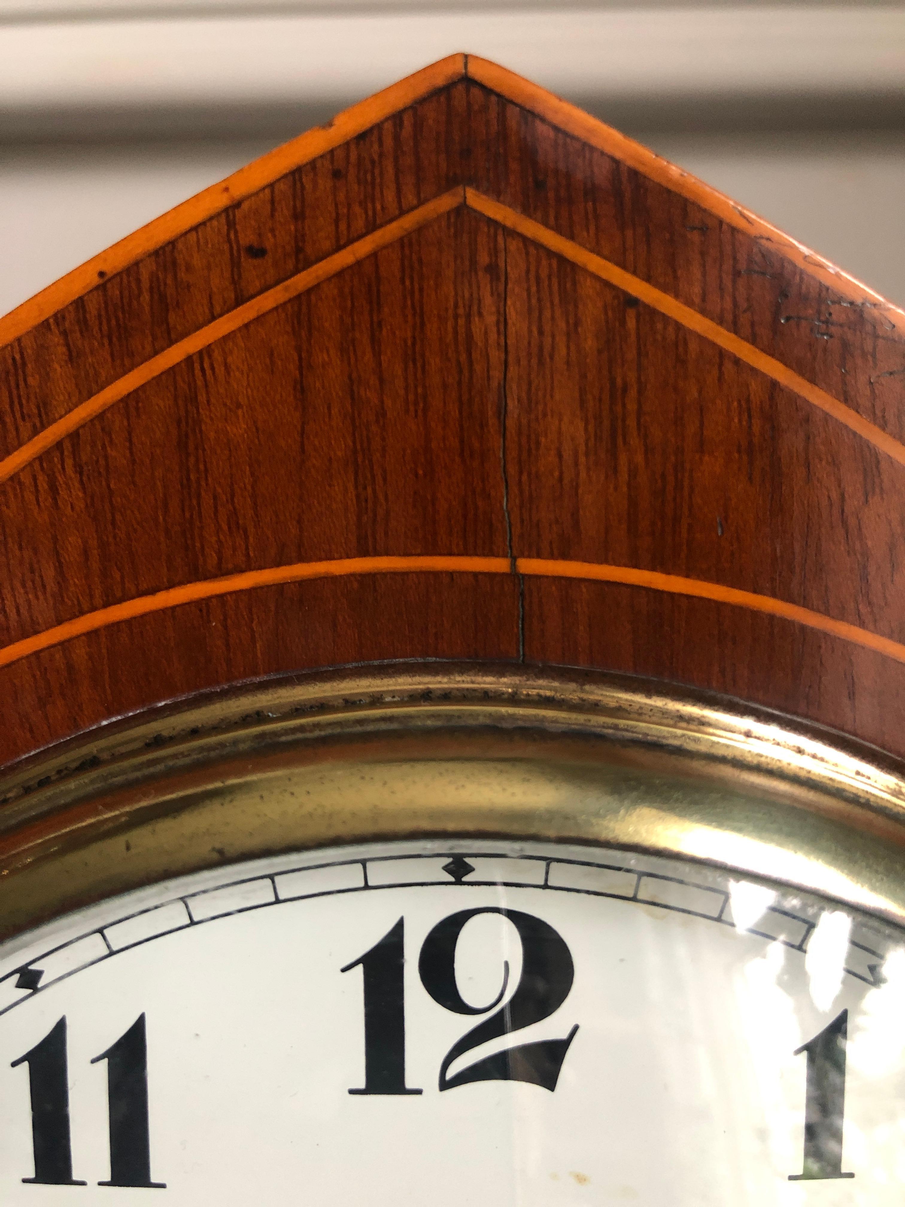Antique Edwardian mahogany lancet top mantel clock having attractive inlaid boxwood stringing and a satinwood fan inlay to the front of the case. The French movement has a white enamel dial and the antique clock strikes the hours and half hour on a