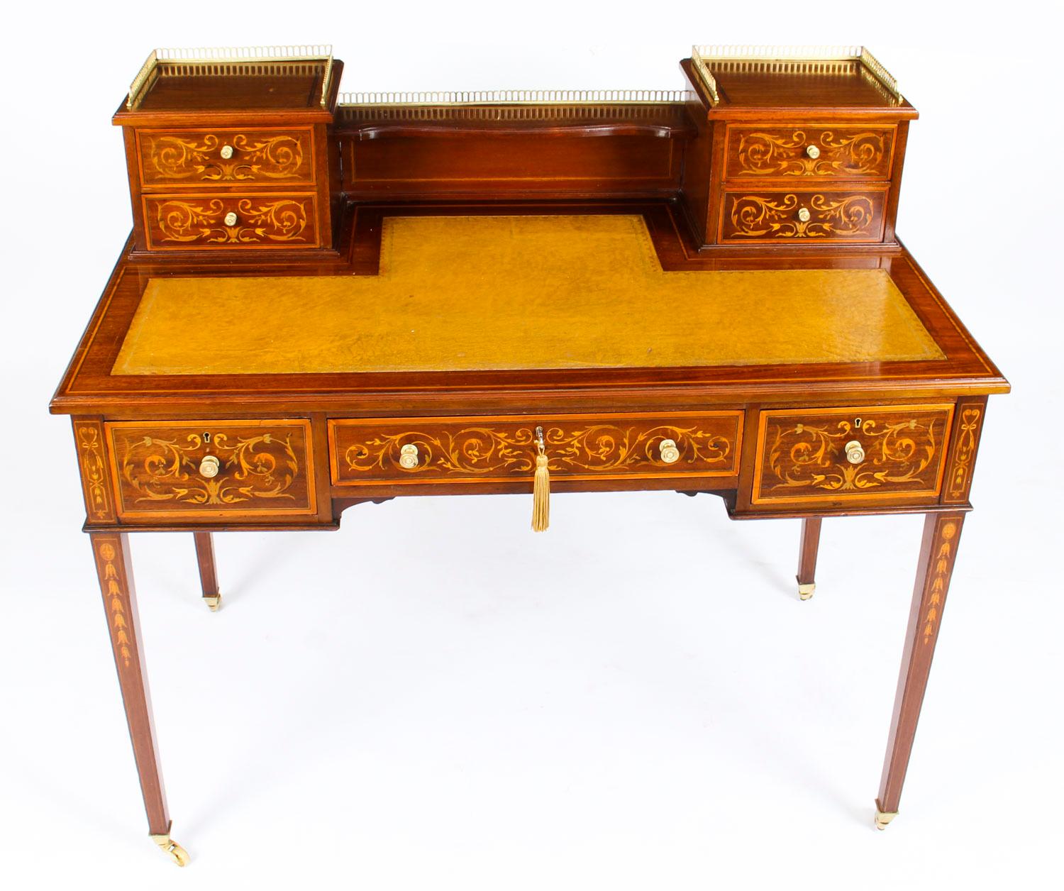 This is a beautiful Edwardian mahogany and Marquetry writing table, circa 1900 in date.
 
The rectangular top features a raised back with two small mahogany lined drawers above its original mustard yellow gold tooled inset leather writing