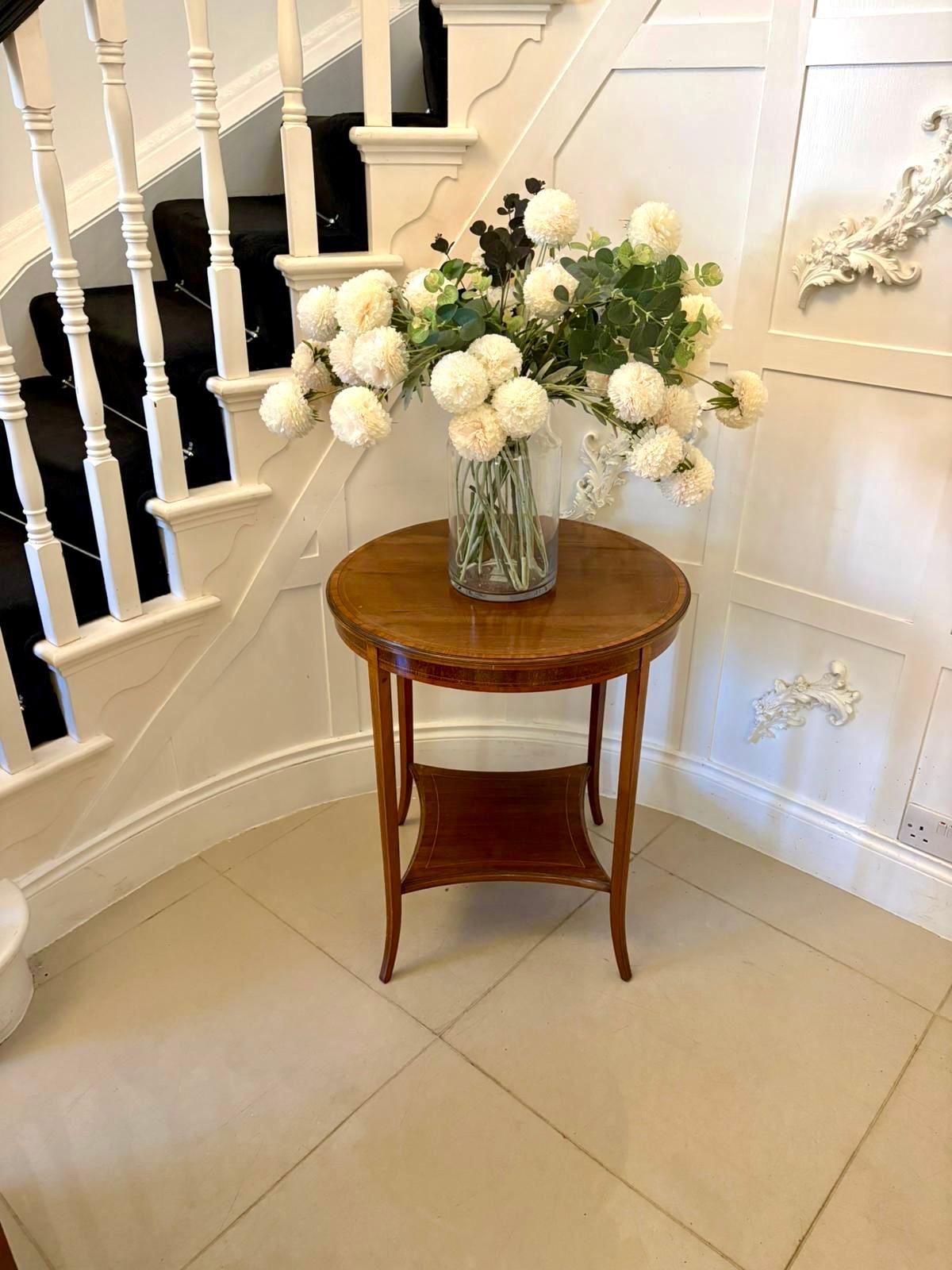 A refined Edwardian mahogany occasional table of elegant proportions enriched throughout with finely executed satinwood inlay. The circular top features a beautifully laid satinwood crossbanded border with additional box-line stringing complementing