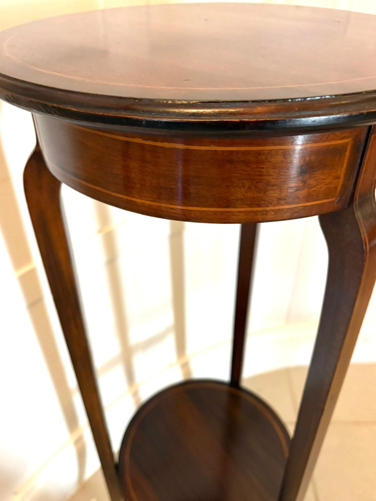 Ein raffinierter edwardianischer Jardiniere-Ständer aus Mahagoni mit eleganter Satinholzeinlage, die dem Stück einen subtilen und doch auffälligen Kontrast verleiht. Die runde Tischplatte ist mit einer zarten Satinholzintarsie versehen, die in eine