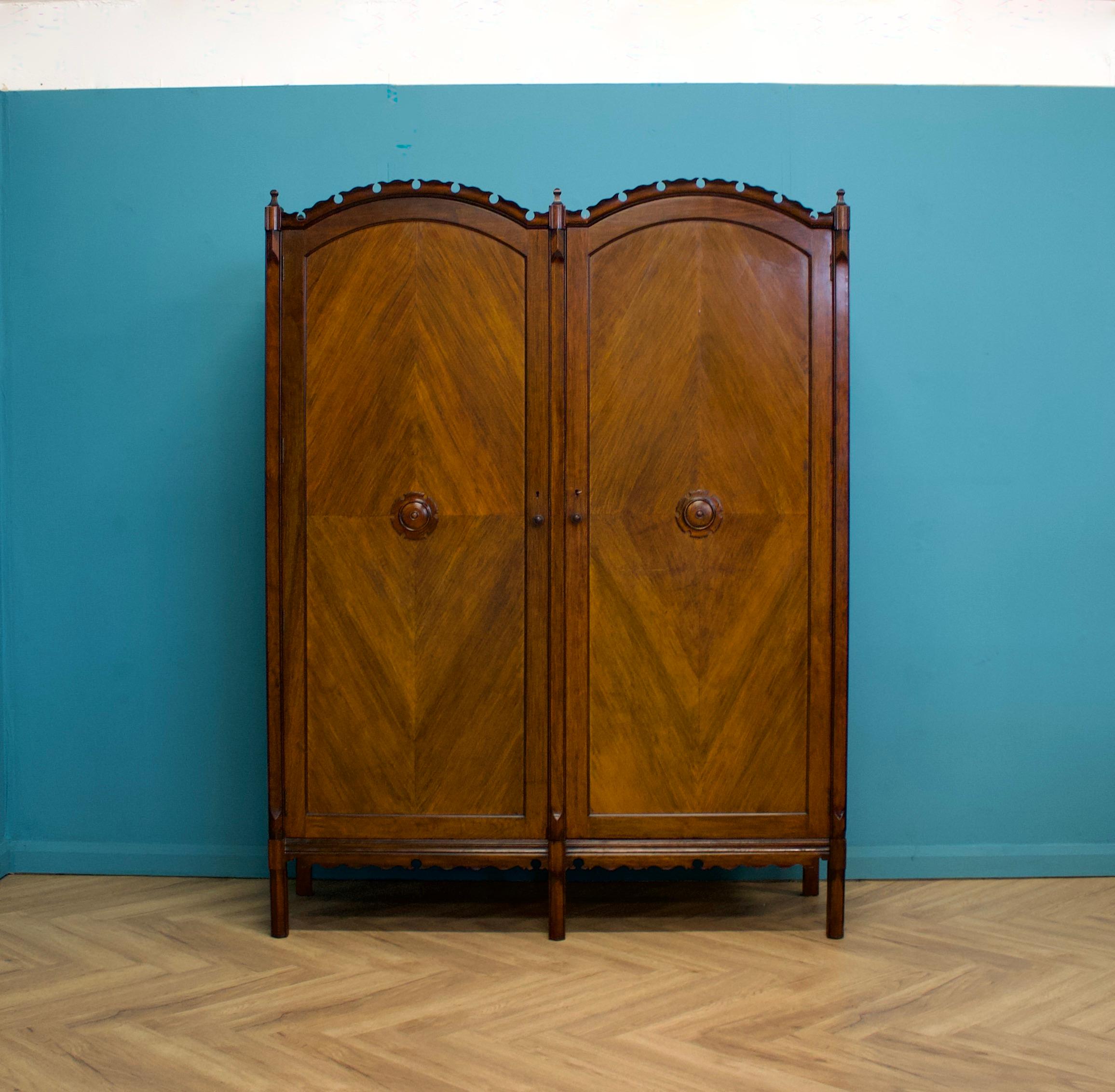 Un imponente armadio in mogano di qualità, progettato da Basil Archer per Harris Lebus, risalente agli anni 1900-1910.


Il design è tipico di Archer, che mescola una varietà di stili per ottenere un pezzo unico straordinario.


L'interno è dotato