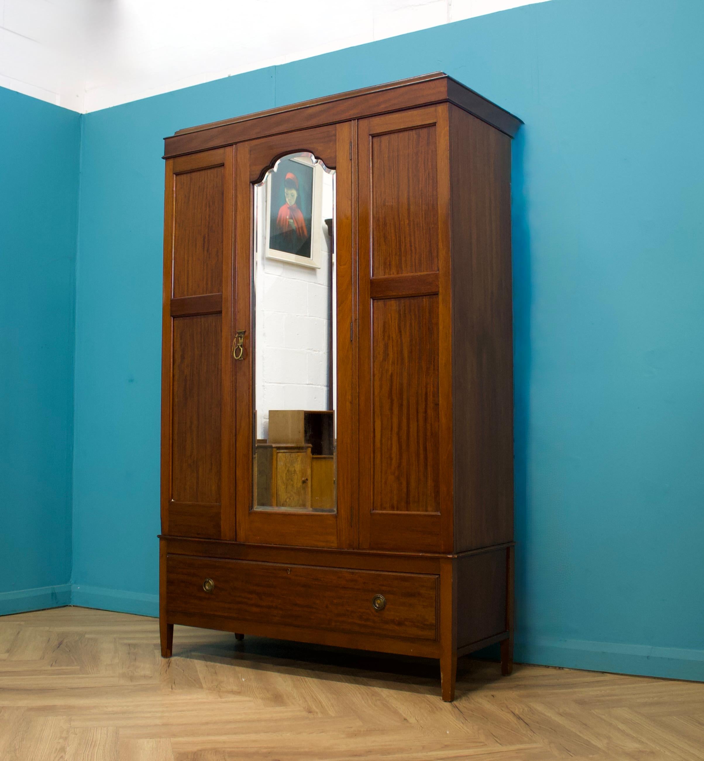 Ein edwardianischer Mahagonischrank oder eine Dielengarderobe  - um 1900
 
Im Inneren befinden sich zwei Kleiderstangen und Kleiderhaken (auf Wunsch können wir eine Kleiderstange aus Messing in voller Breite anbringen)
Unten befindet sich eine