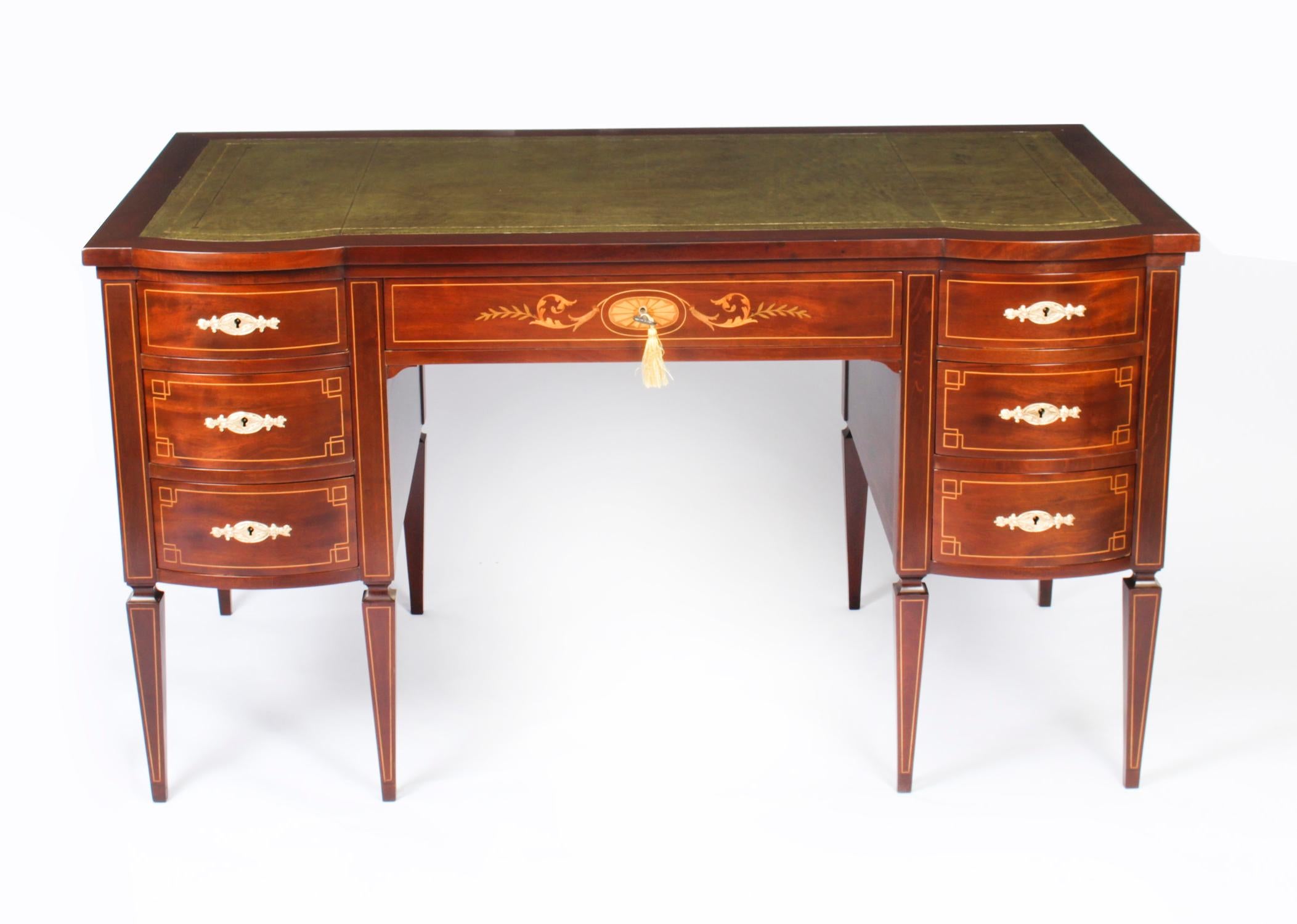 This is a stunning antique Edwardian writing desk, circa 1890 in date and in the manner of the renowned retailer and cabinet maker Edwards & Roberts.

It is made of solid mahogany and has fabulous inlaid decoration, the central frieze drawer with