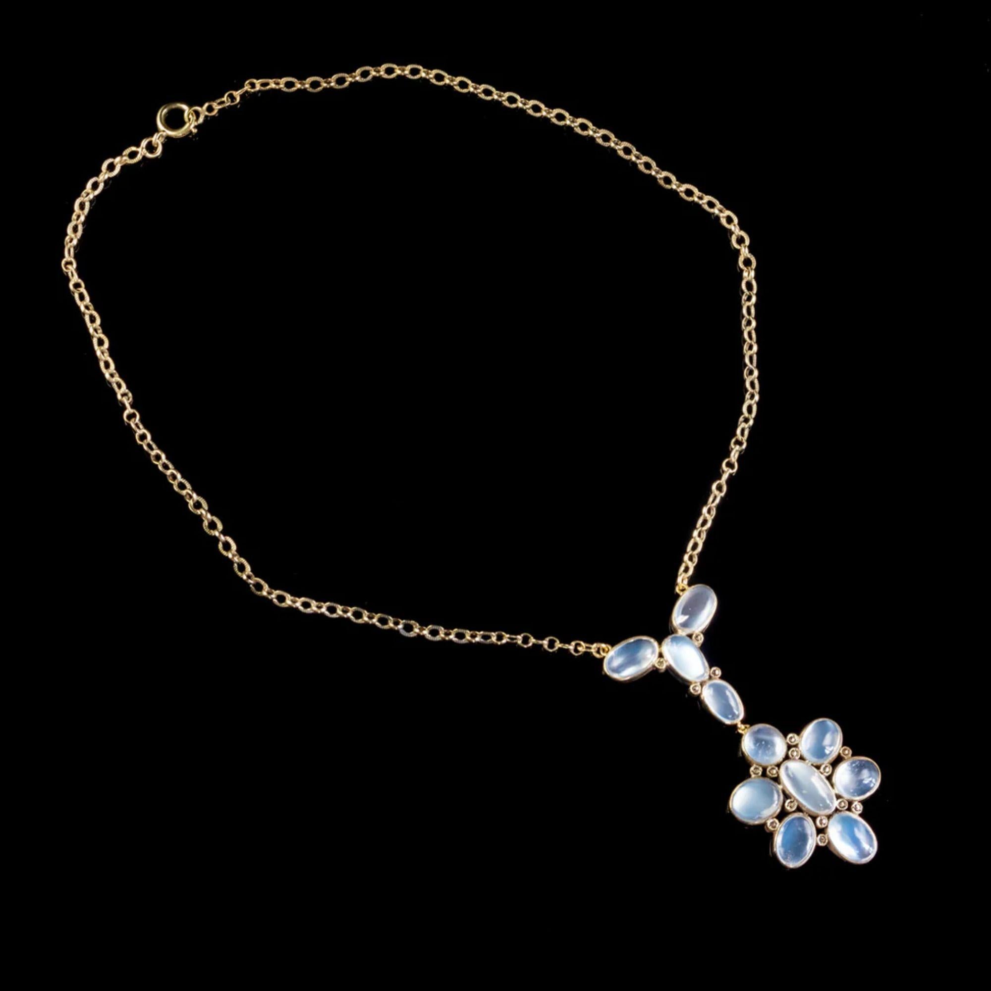 A fabulous antique Edwardian moonstone lavaliere necklace modelled in silver and gilded in 18ct yellow gold. It features a distinctive pendant, bezel set with eleven cabochon moonstones (approx. 17ct total) arranged in an abstract, flower