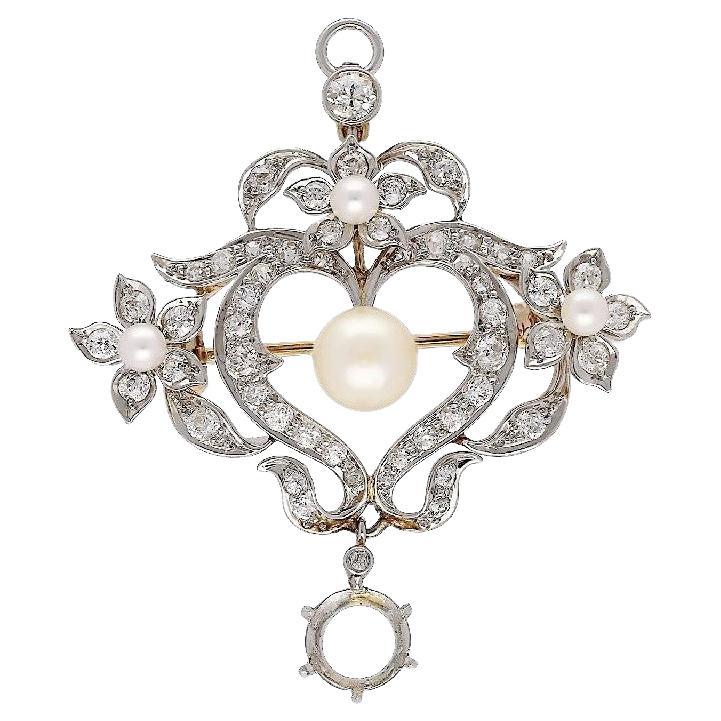 Una antigüedad original de la época eduardiana, hacia 1910, con una perla natural y un diamante de talla europea de 1,69 quilates certificado por el GIA. La encantadora pieza presenta 3 perlas de siembra junto con una perla redonda natural de 8 mm