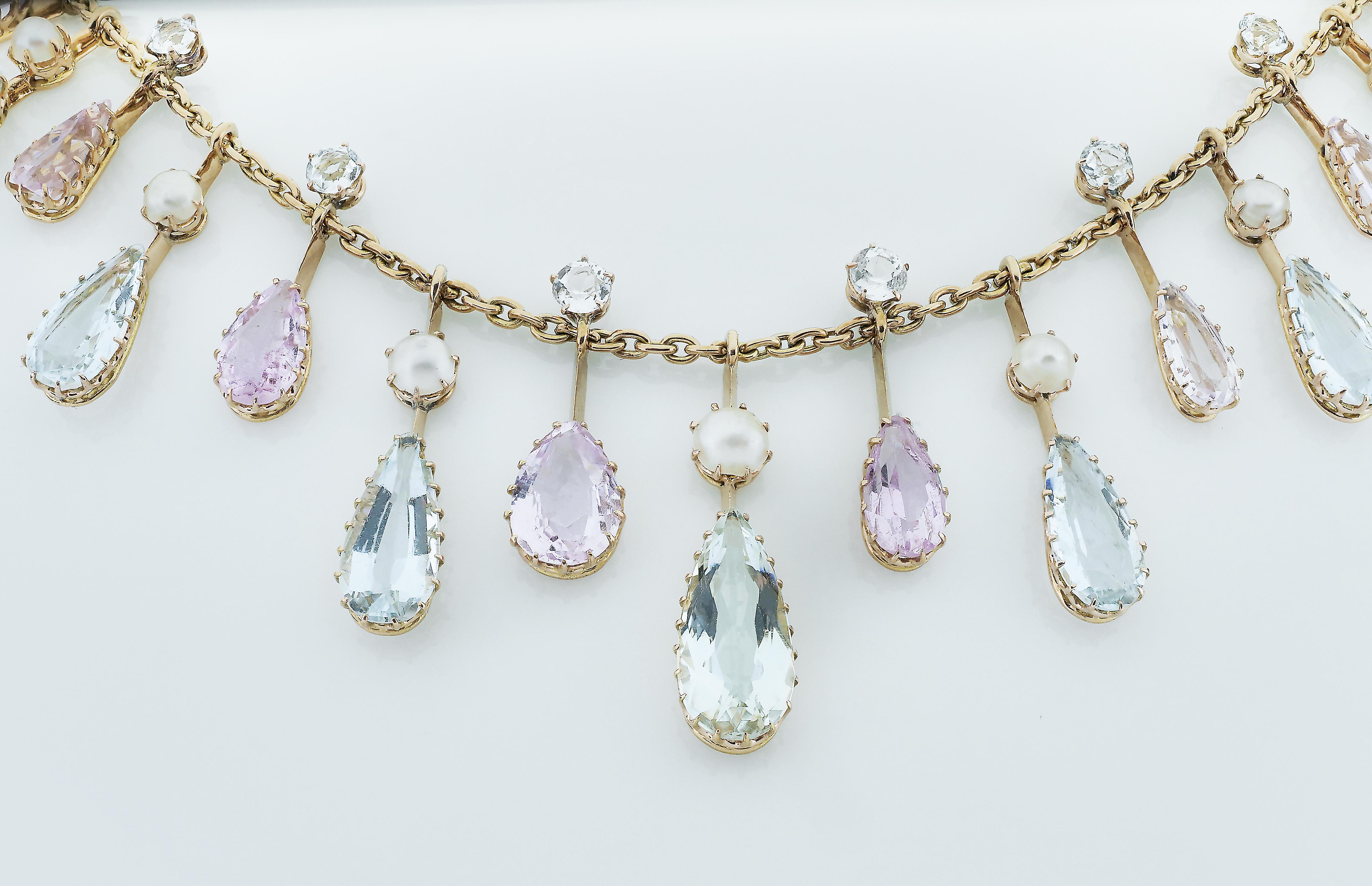 Timeless antique necklace travelling from the 1900. A beautiful fringe necklace set with pink topaz and aquamarine in it’s original fitted box. The necklace design as alternating pattern of dangling pink topaz and sky blue aquamarine. On each