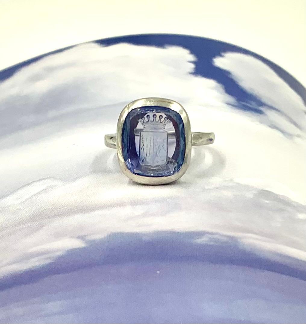 Antique Edwardian 4.45 carat sapphire intaglio platinum signet ring
Early 20th Century
Sapphire: 10mm by 11mm by 4mm, approximately 4.45 carats, facet cut at the sides and back with a finely engraved itaglio depicting a Baronet crown, a lion and