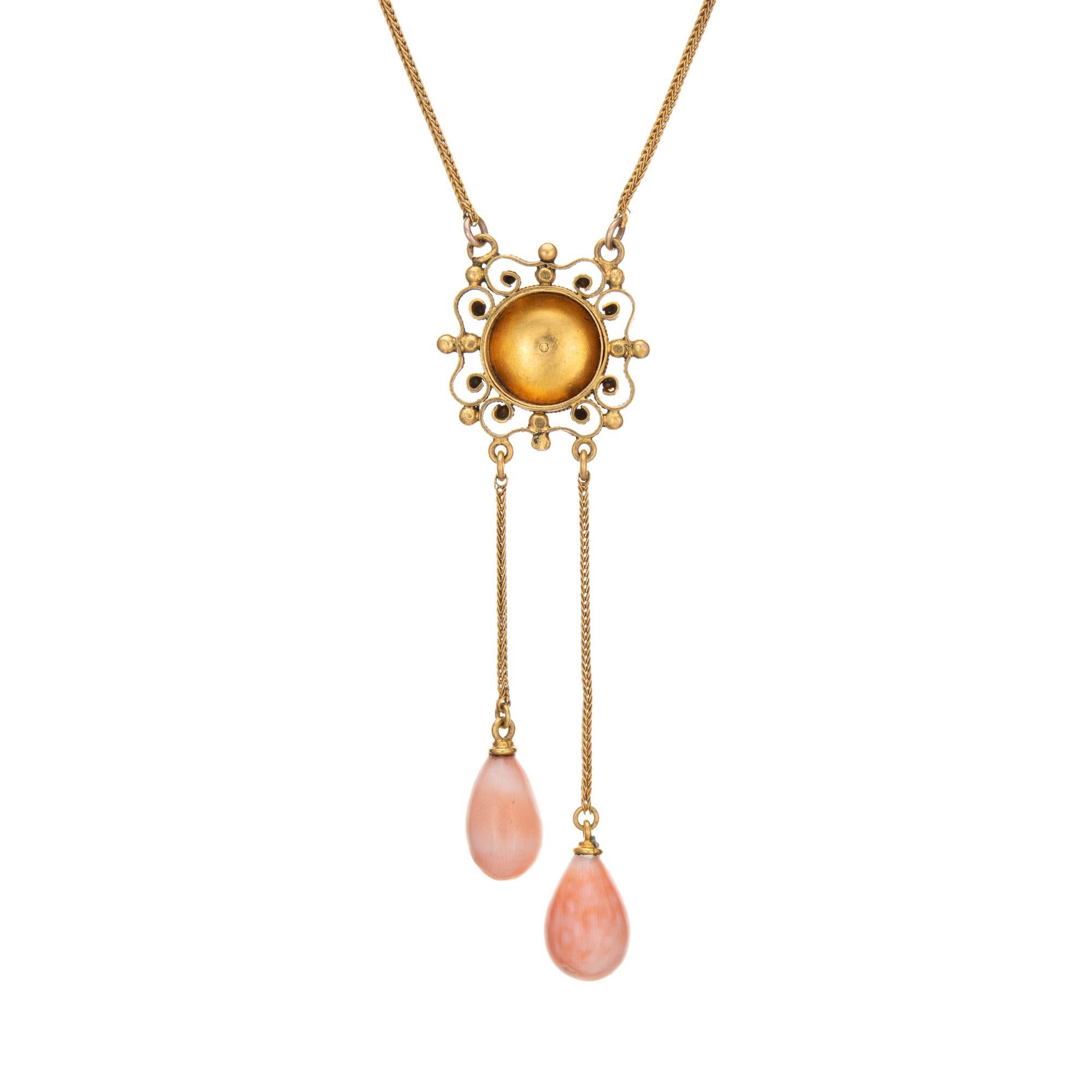 Finely detailed antique Edwardian era negligee drop necklace (circa 1900s to 1910s), crafted in 18k yellow gold. 

The elaborate circular mount is set with 7mm coral, with two coral drops measuring 12mm x 7mm. The coral is in very good condition and
