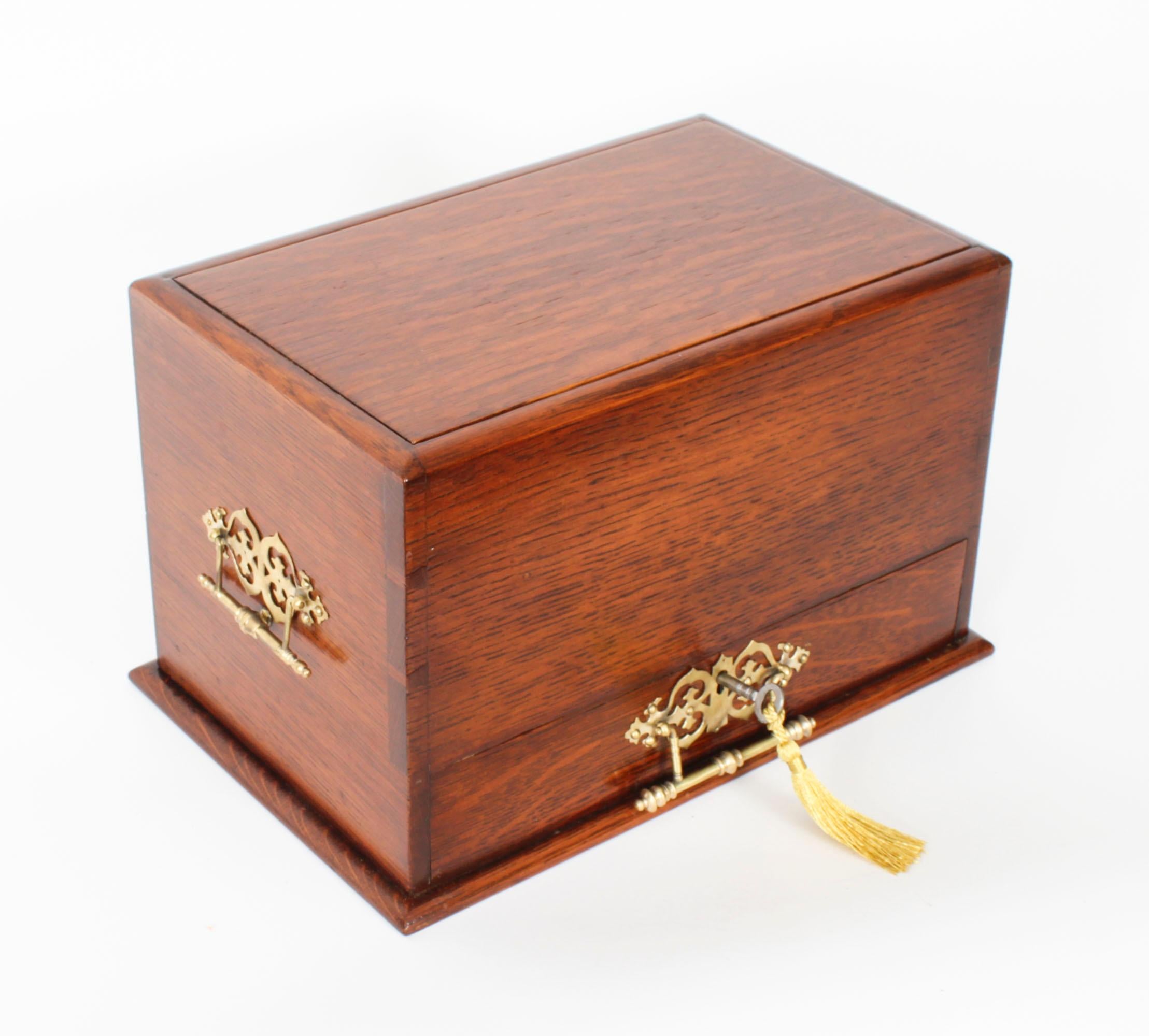 Raro mobile da cartoleria antico in legno di quercia a forma rettangolare, con piano a battente e frontale a scomparsa che racchiude degli scompartimenti, datato Circa 1900.

L'armadietto presenta maniglie in stile gotico ormolu e un cassetto che